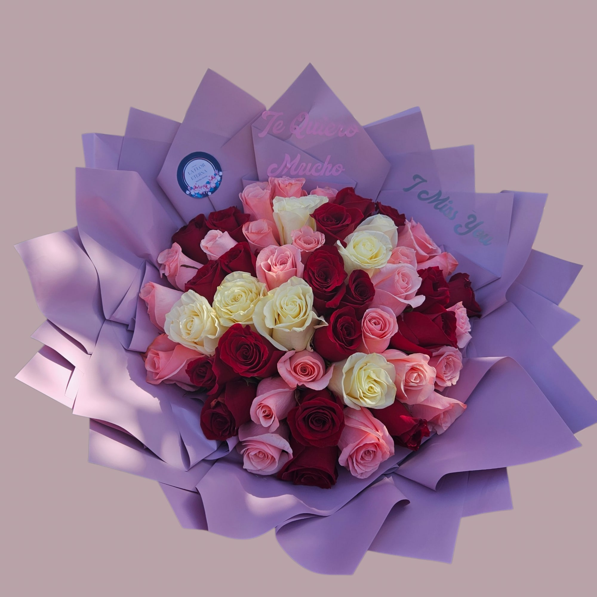 A lush hand-tied bouquet of roses in deep red, blush pink, creamy