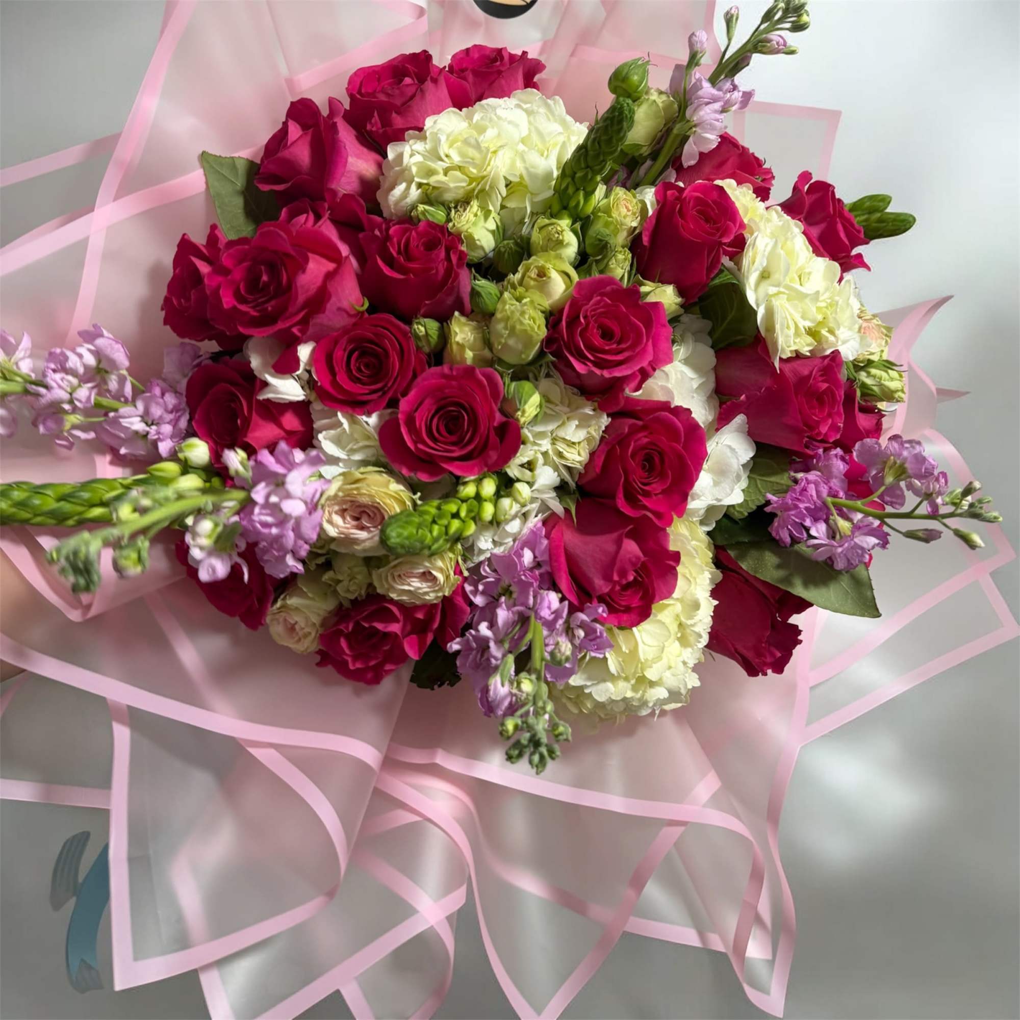 A beautifully handcrafted bouquet featuring a curated selection of fresh, mixed flowers.