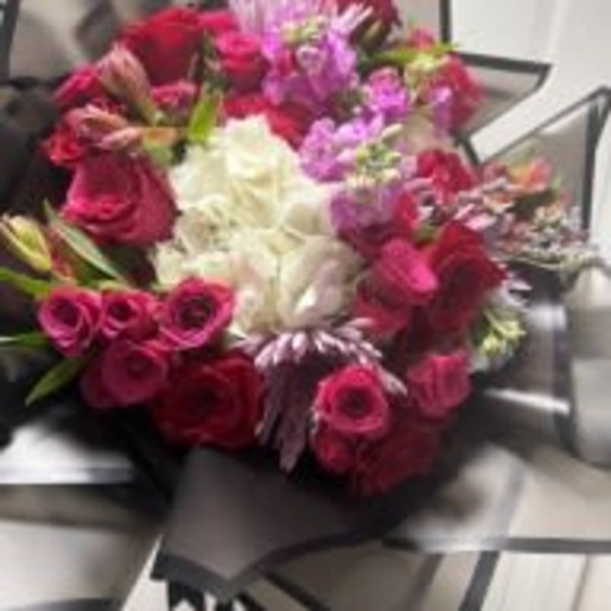 A beautifully handcrafted bouquet featuring a curated selection of fresh, mixed flowers.