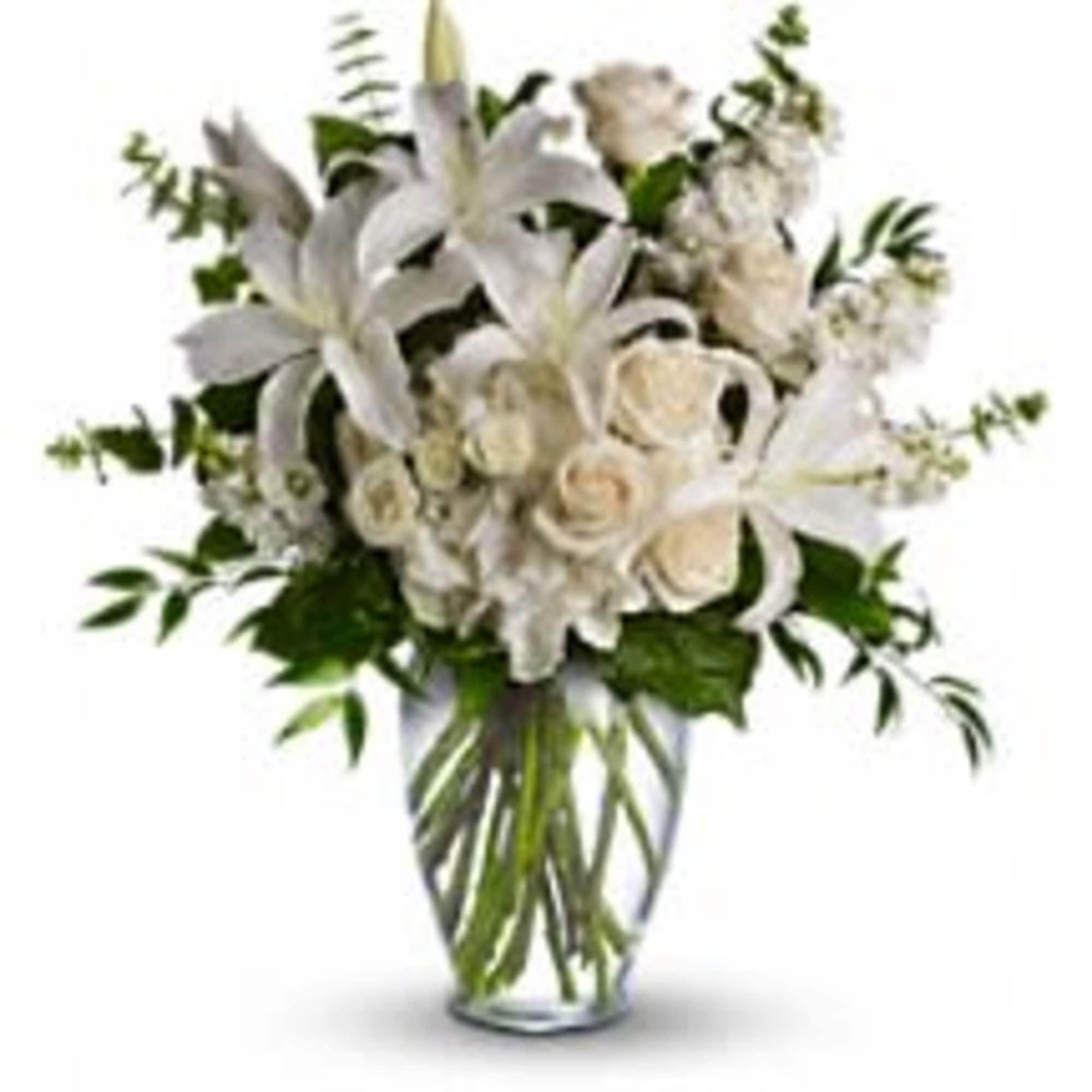 White lilies and roses arranged in a clear glass vase