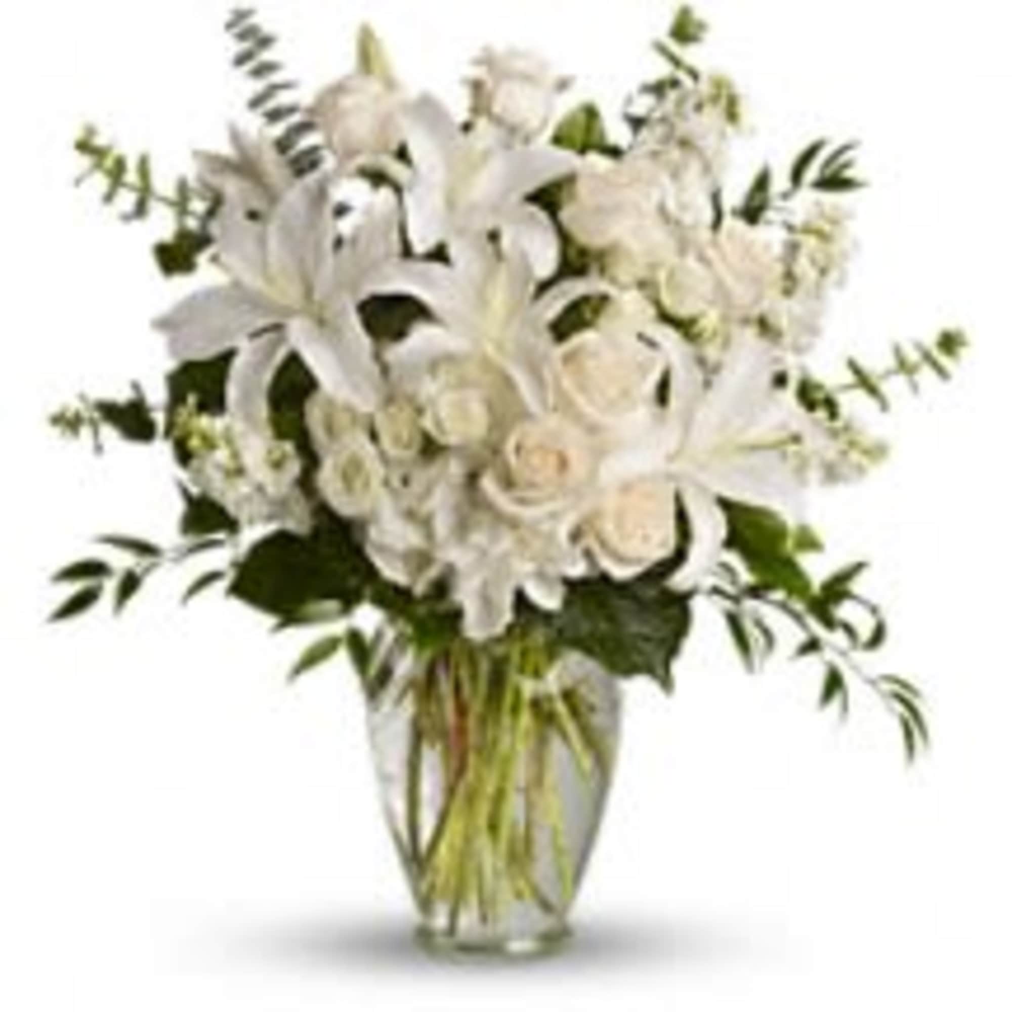 White lilies and roses arranged in a clear glass vase