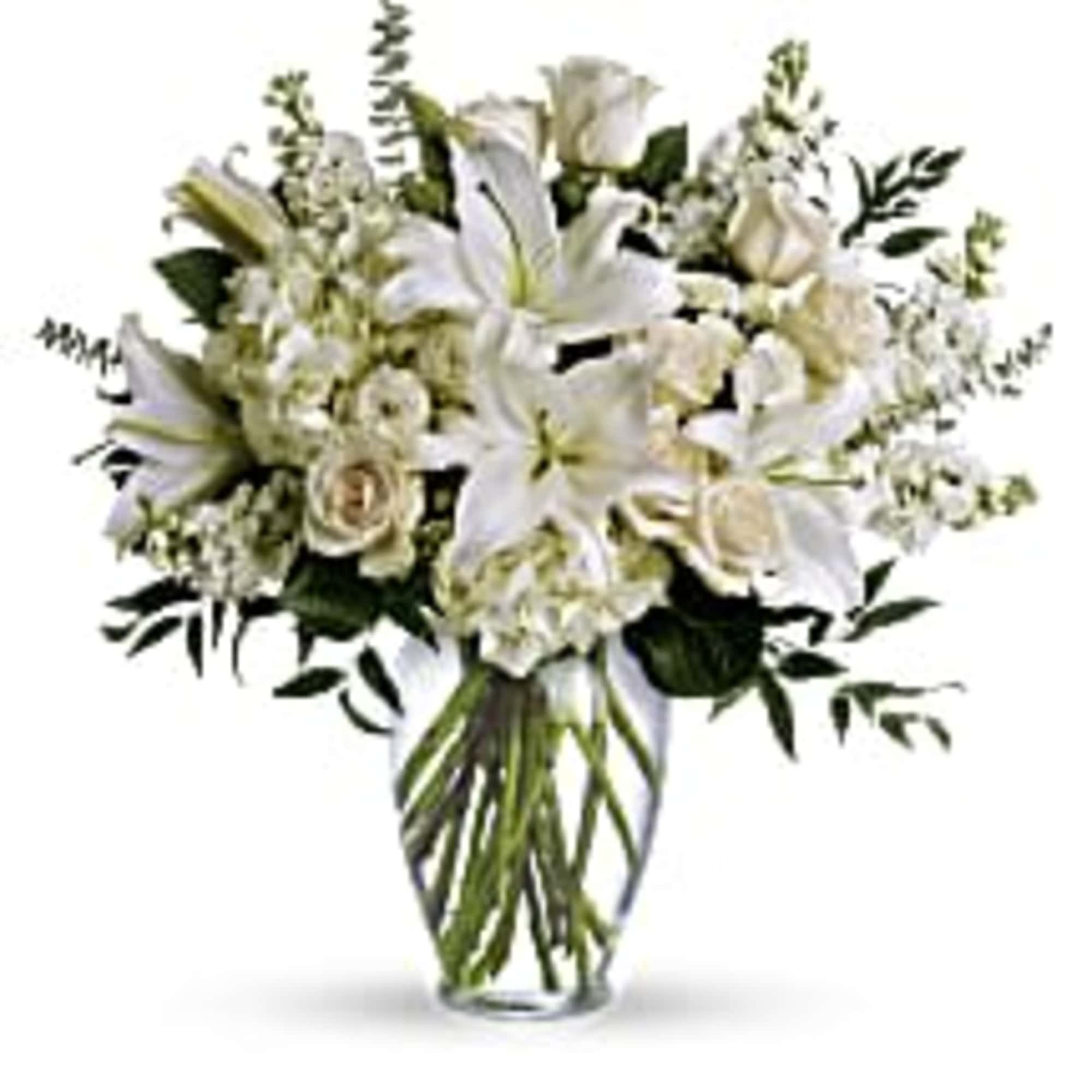White lilies and roses arranged in a clear glass vase