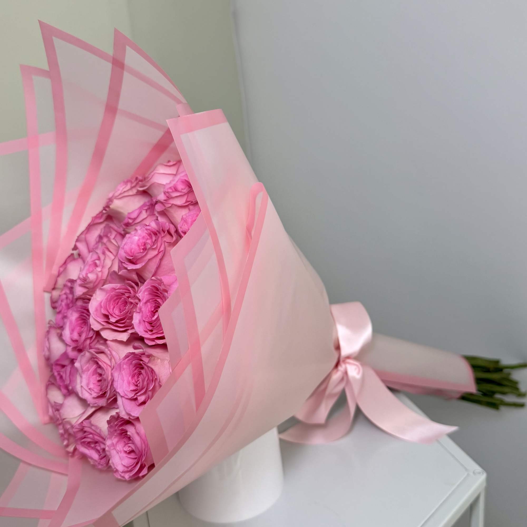 Soft light pink roses wrapped in blush pink paper, topped with a