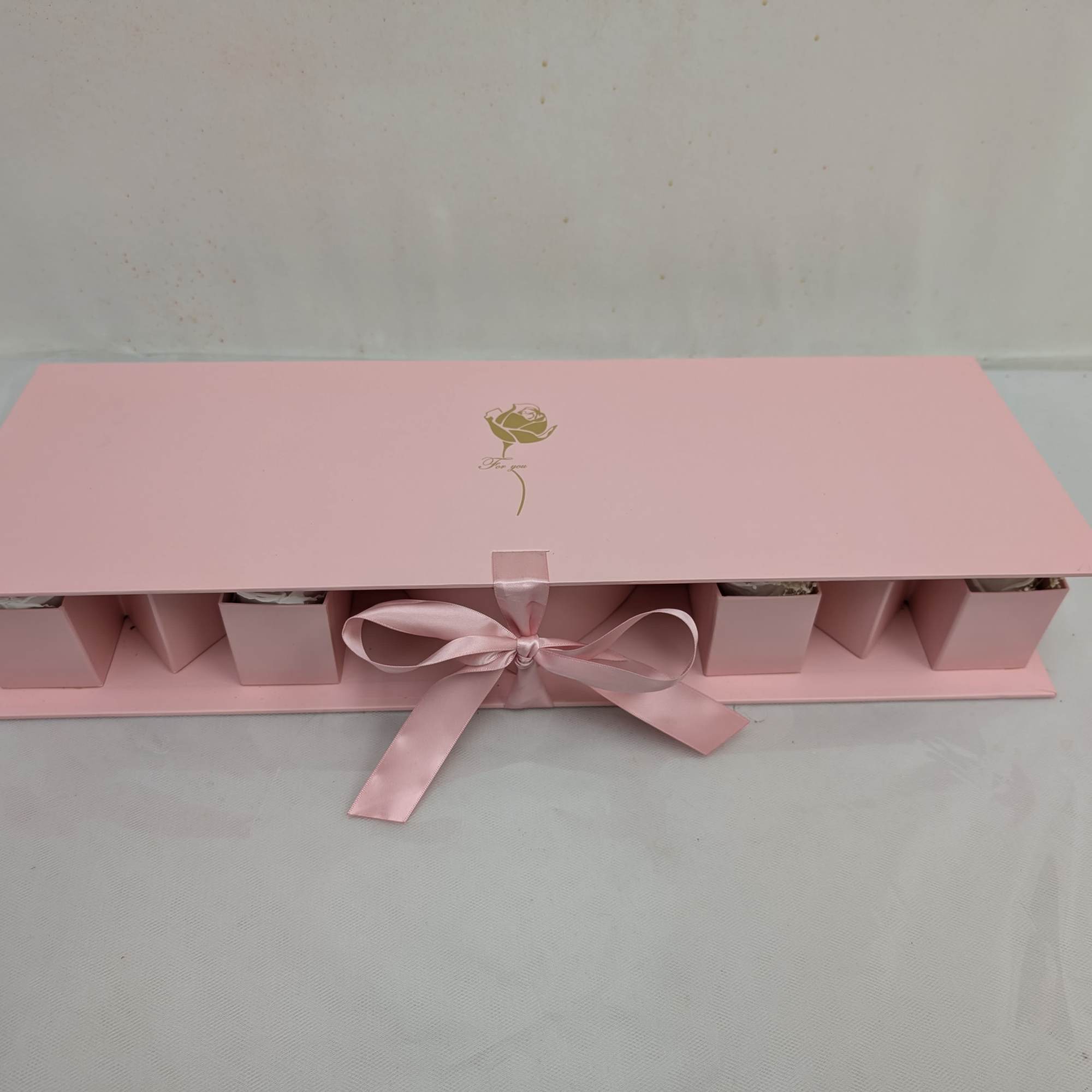 Pink gift box with a satin ribbon and small compartments inside