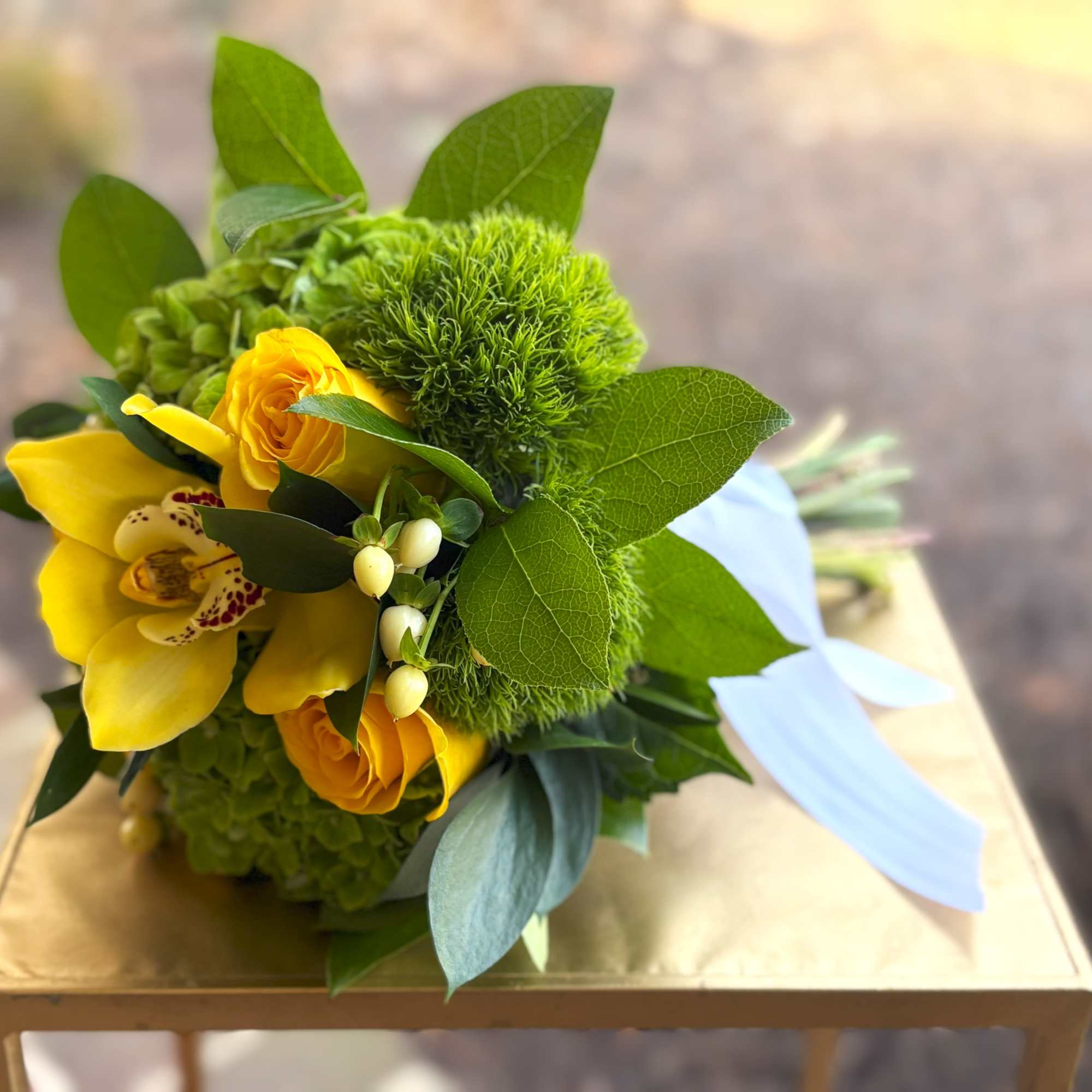 Yellow bouquet with orchids and roses on a gold box