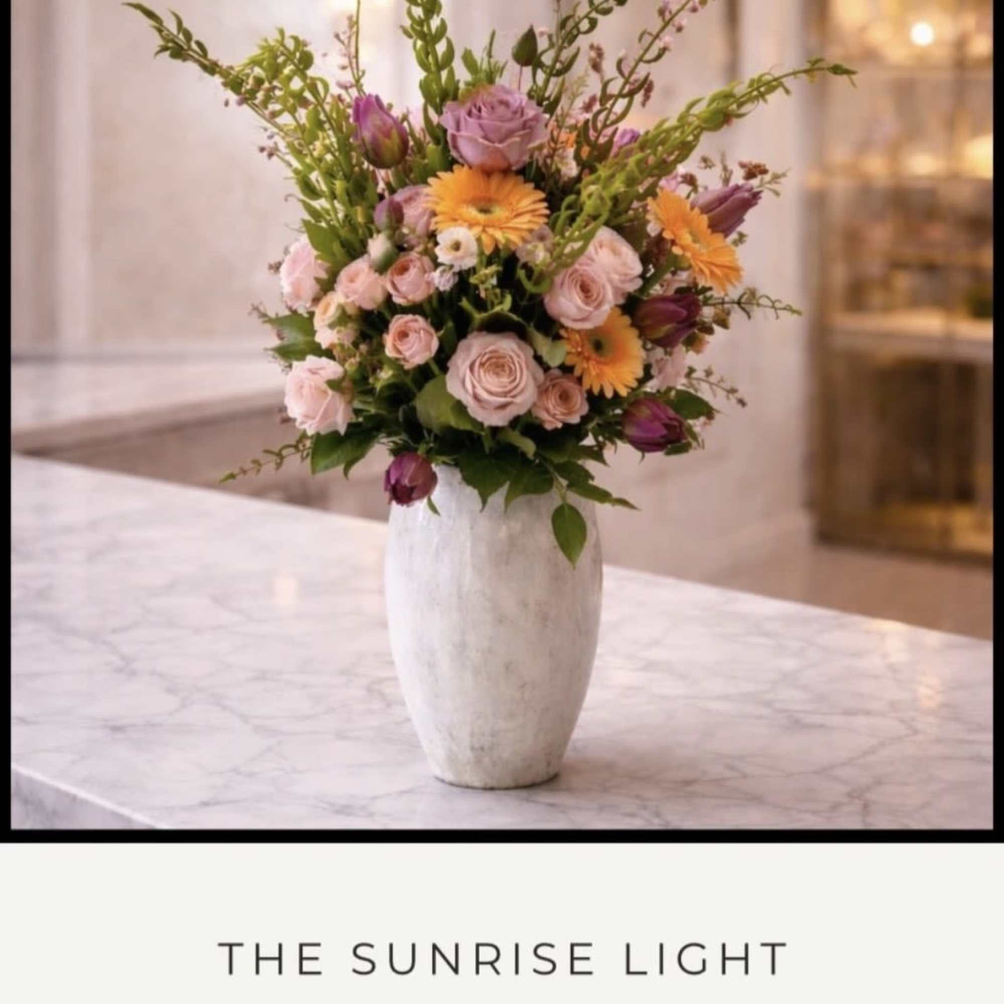 Soft blush roses and lavender blooms mingle with bright orange gerbera daisies