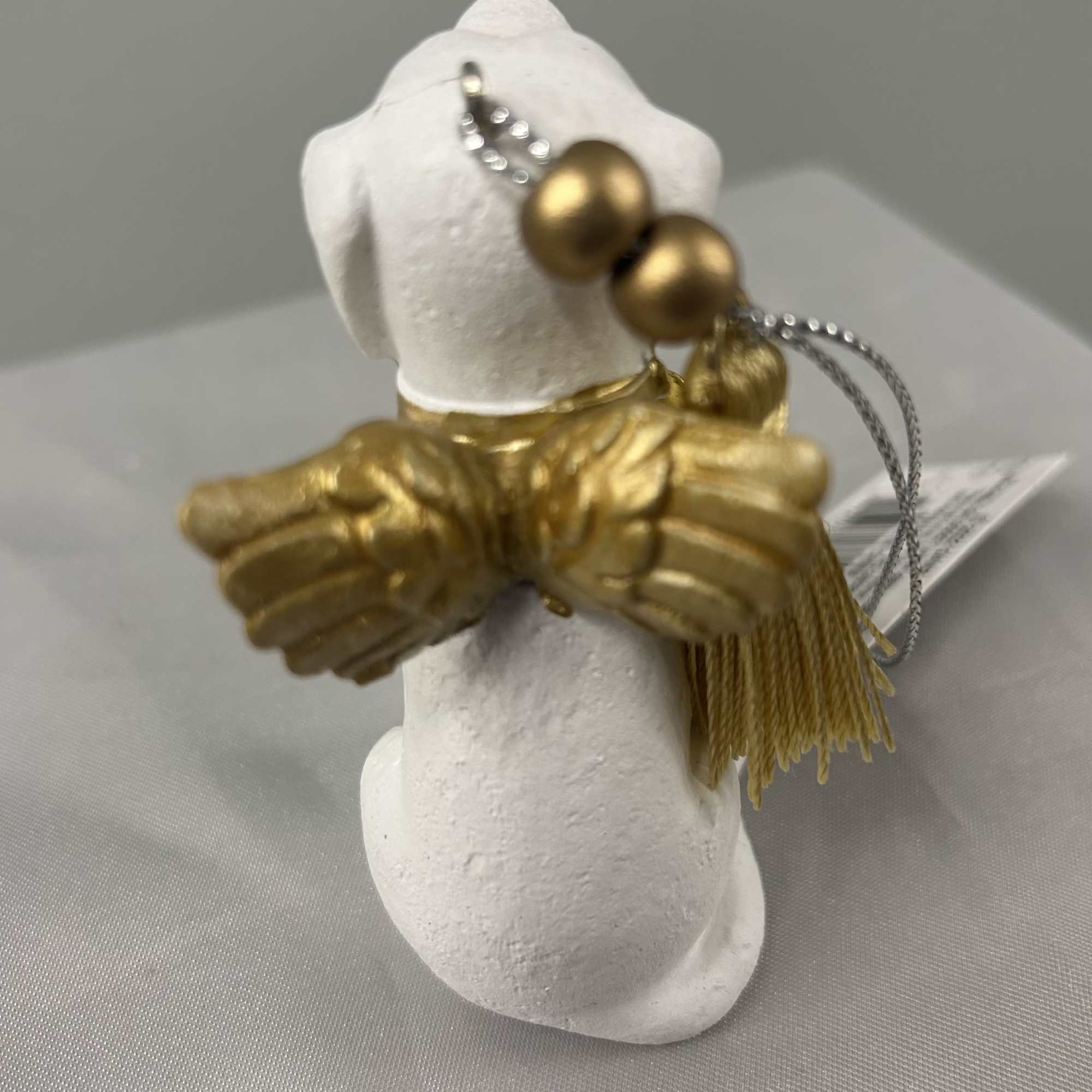 White dog figurine with gold wings and bead accents