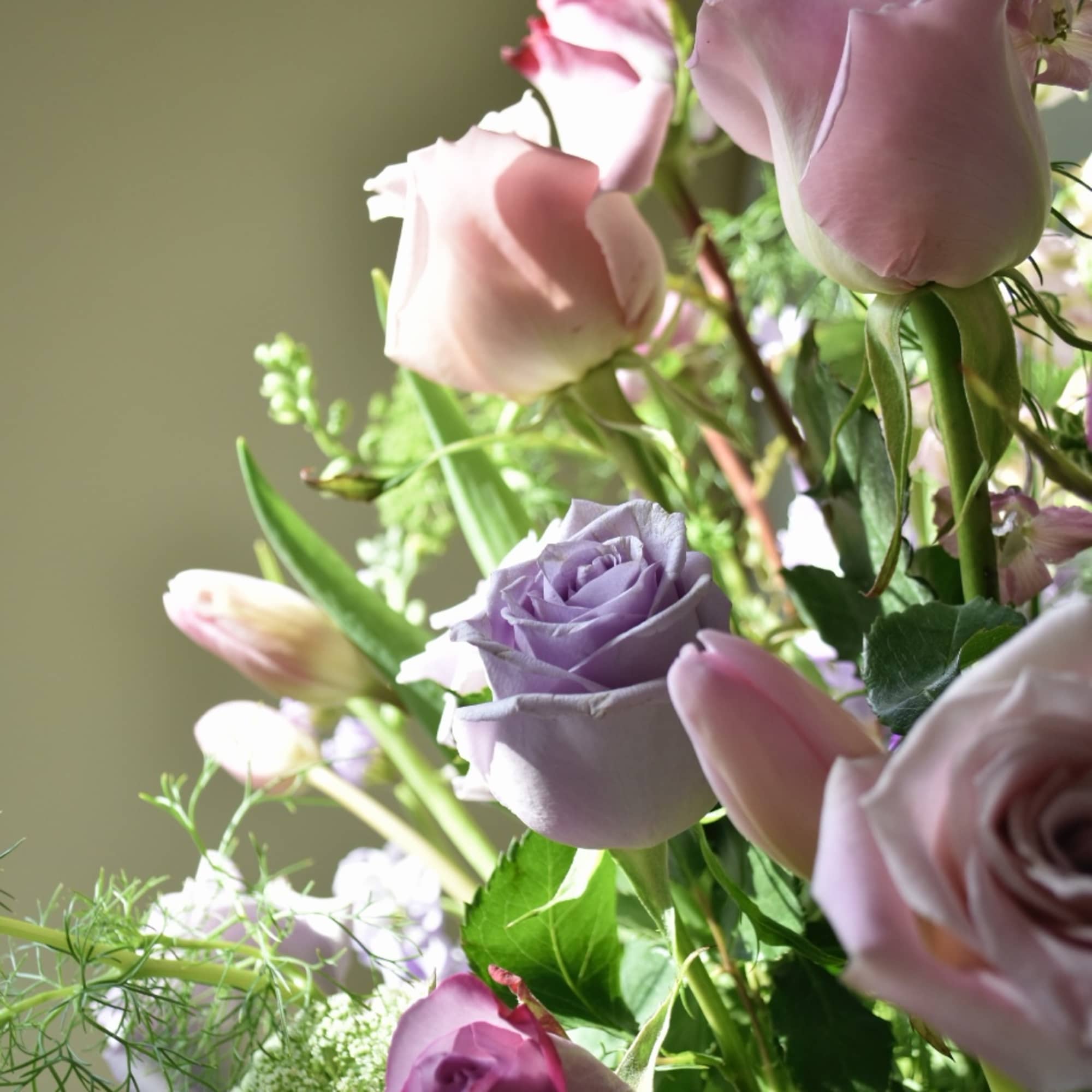 Bouquet of pink and lavender roses with mixed greenery