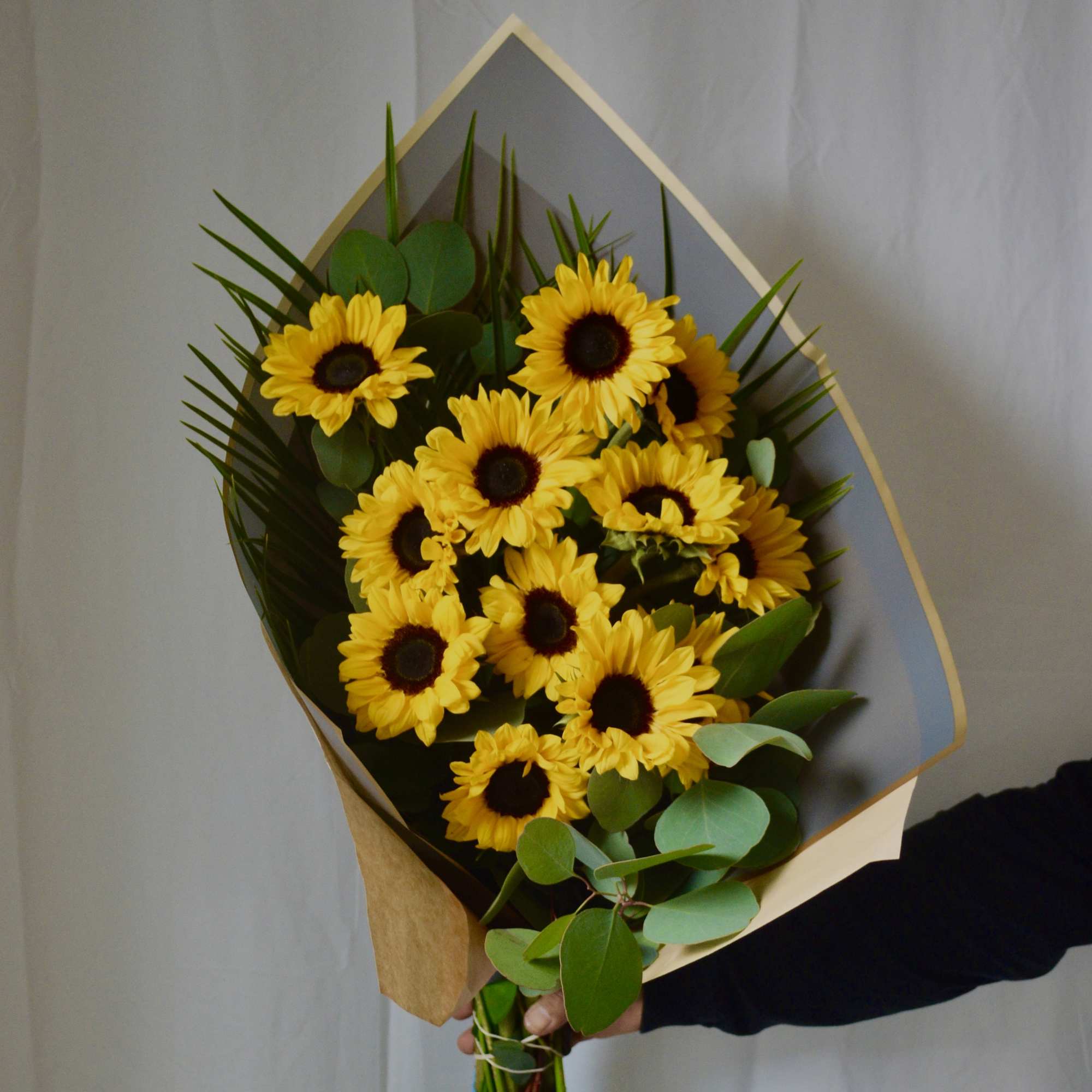 Bouquet of yellow sunflowers wrapped in paper