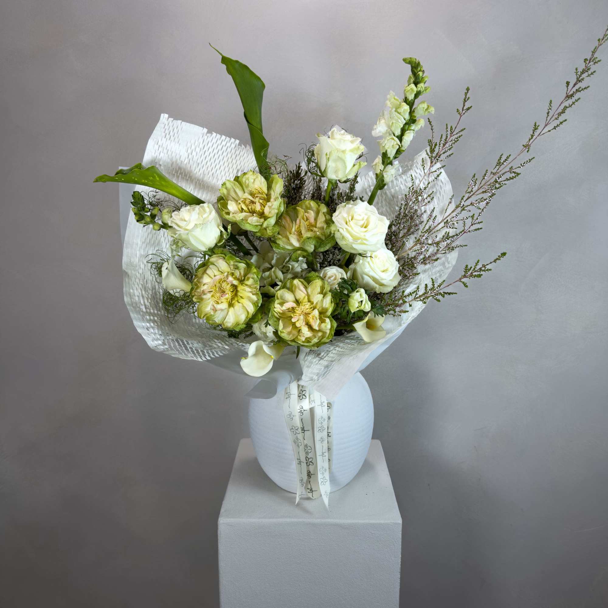 A soft, all-white bouquet composed in layered tones - bringing together seasonal