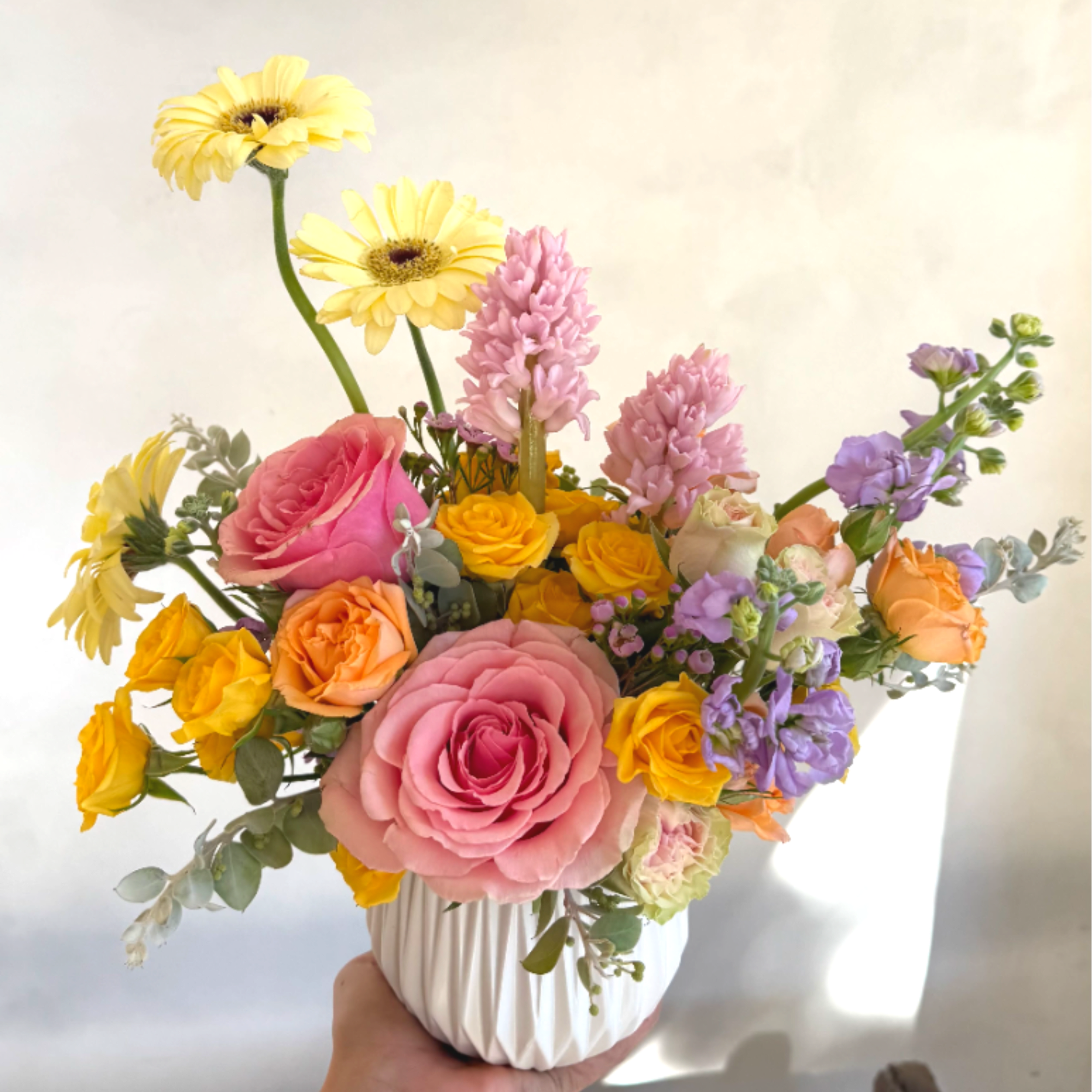 This arrangement features a unique mix of fresh flowers, varying each week