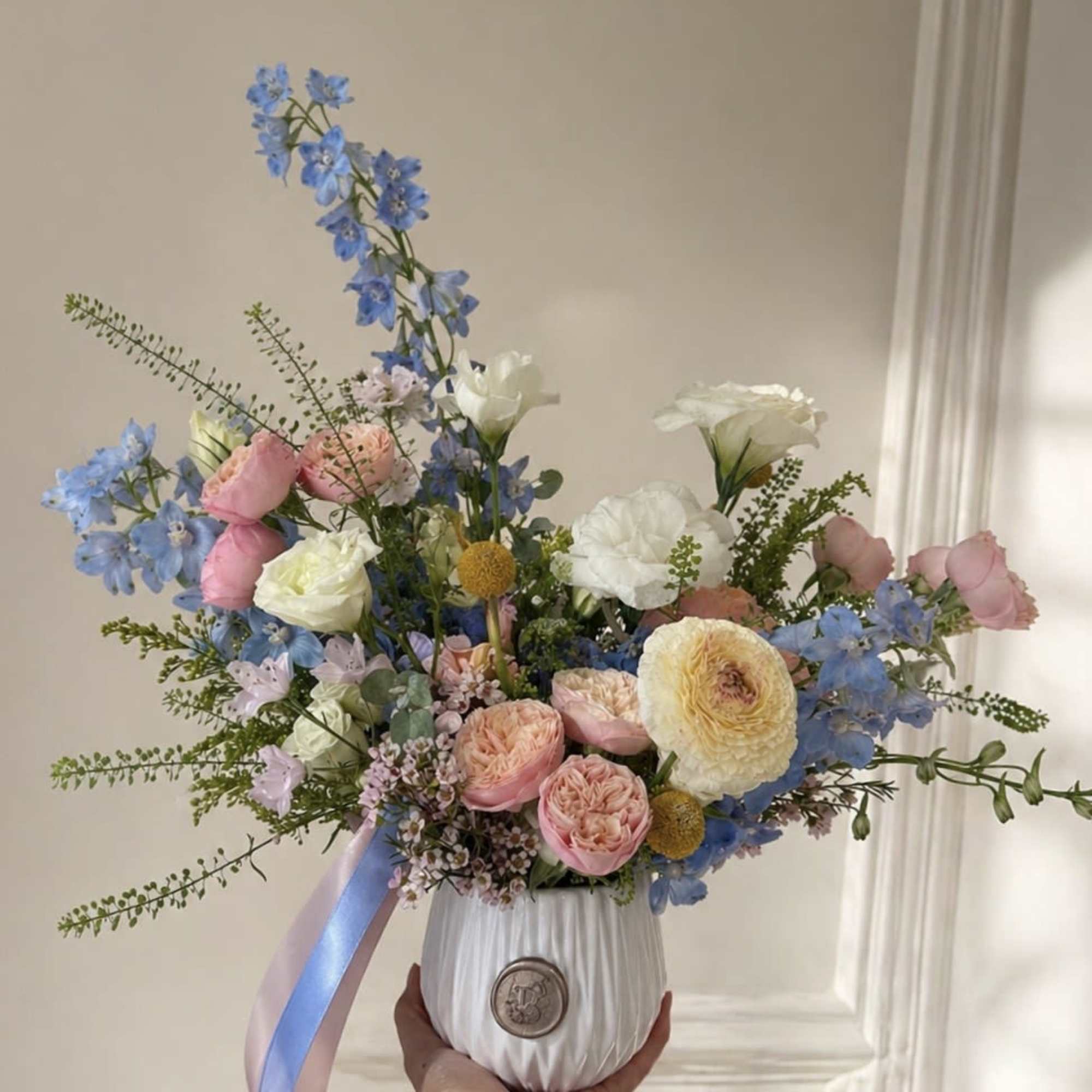 This arrangement features a unique mix of fresh flowers, varying each week