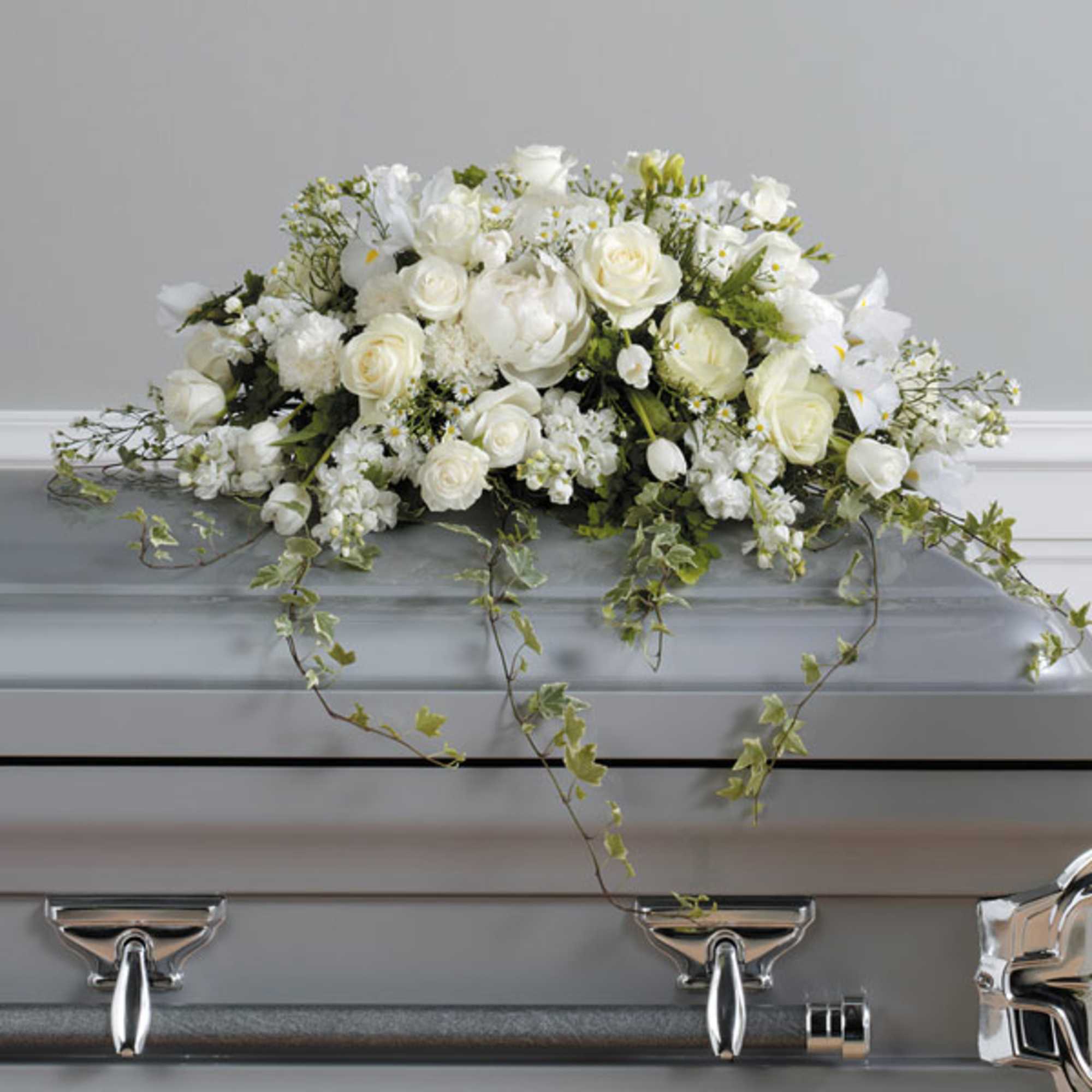 White floral casket spray with roses and trailing ivy