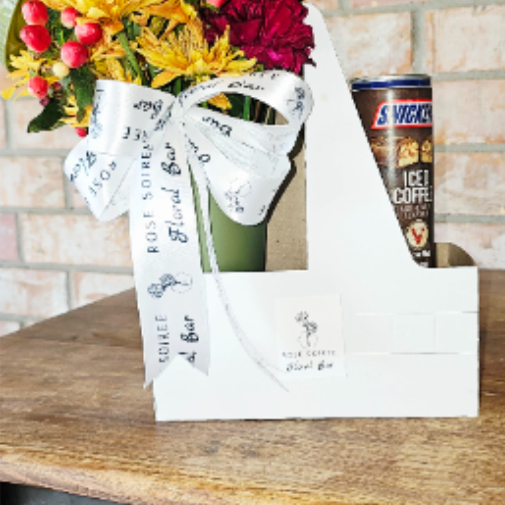 Gift set with yellow and red flower bouquet and canned iced coffee in a white carrier box