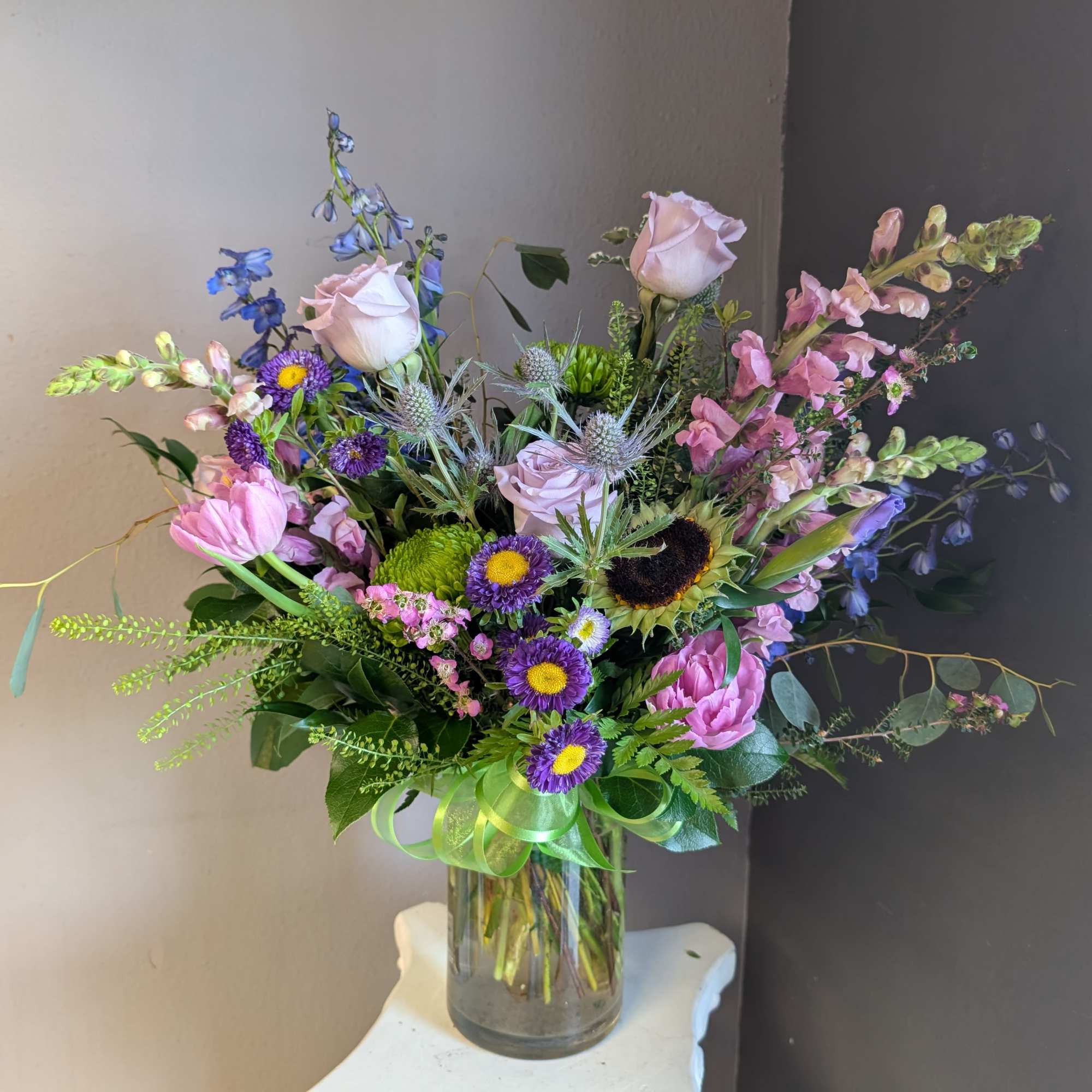 This beautiful flower arrangement of fresh mixed seasonal blooms is made by