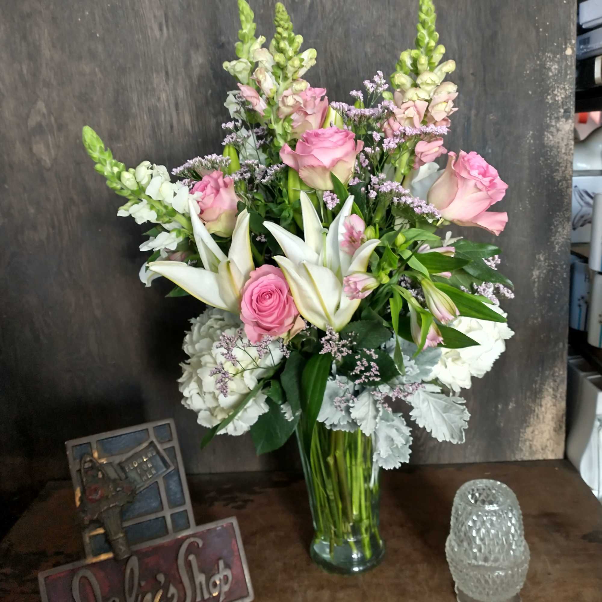 Pink roses and white lilies arranged in a clear glass vase
