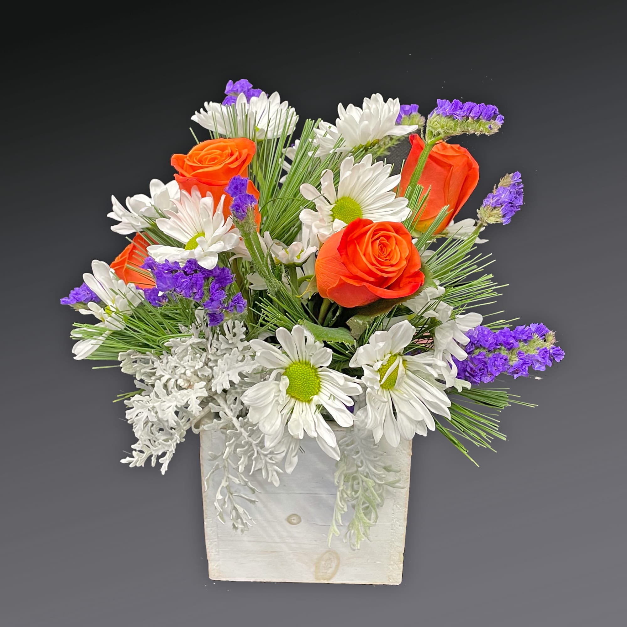 Orange roses and white daisies in a white wooden box