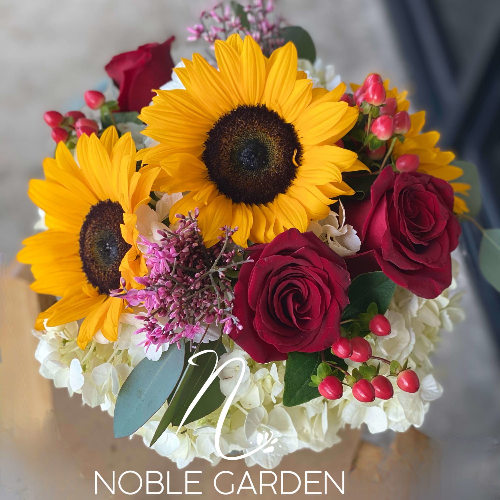 Bouquet of sunflowers, red roses, and white hydrangeas