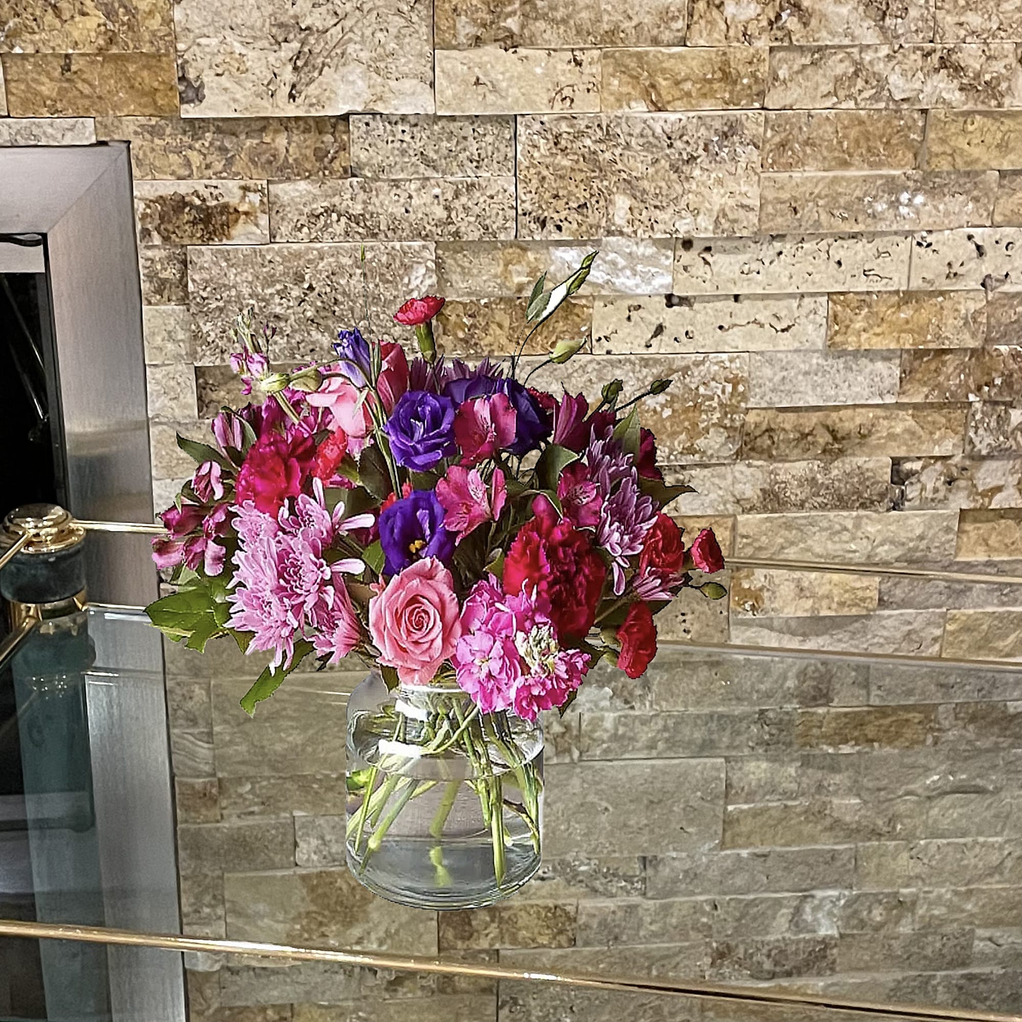 Mixed pink and purple bouquet in a clear glass vase
