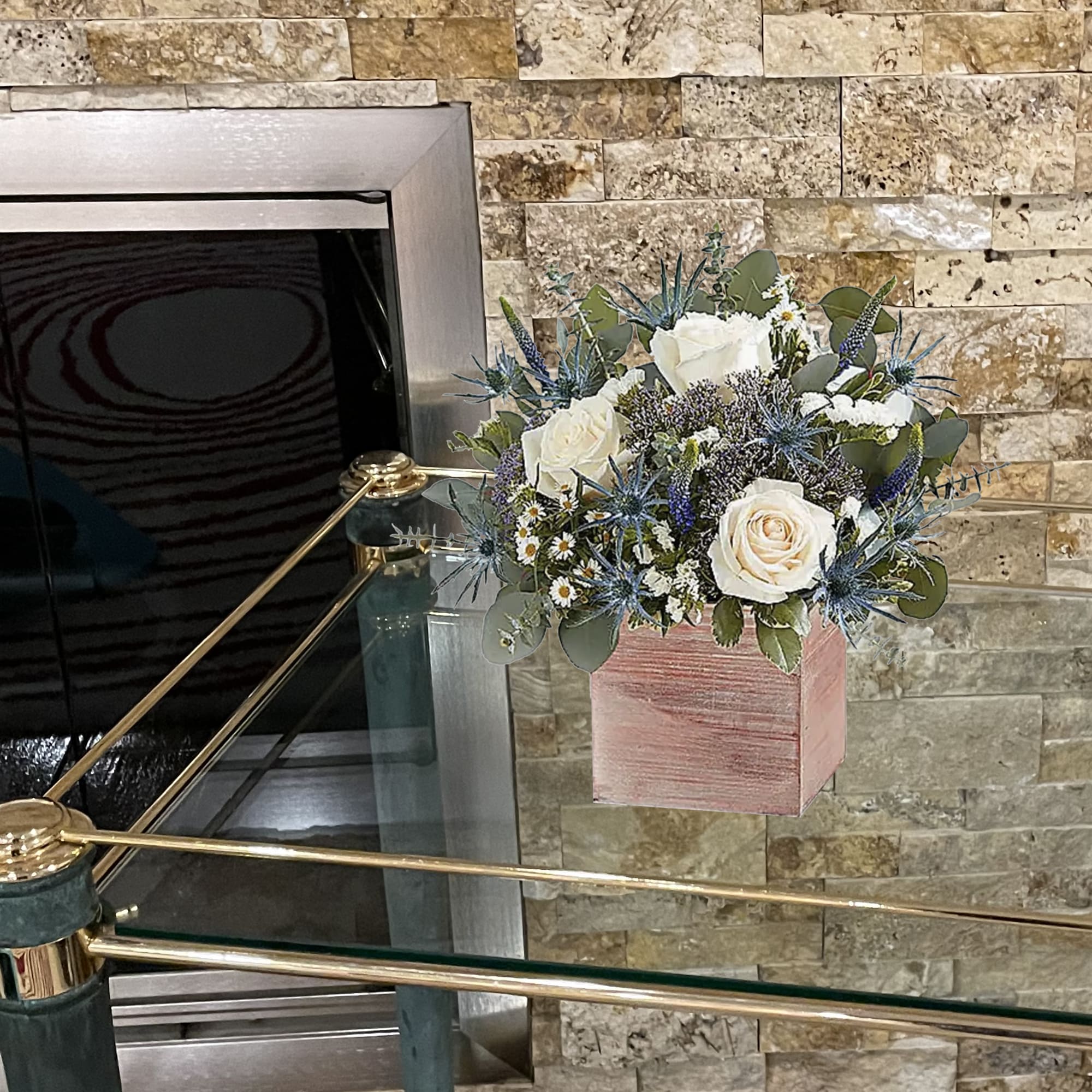 White roses and blue thistle in a pink square box