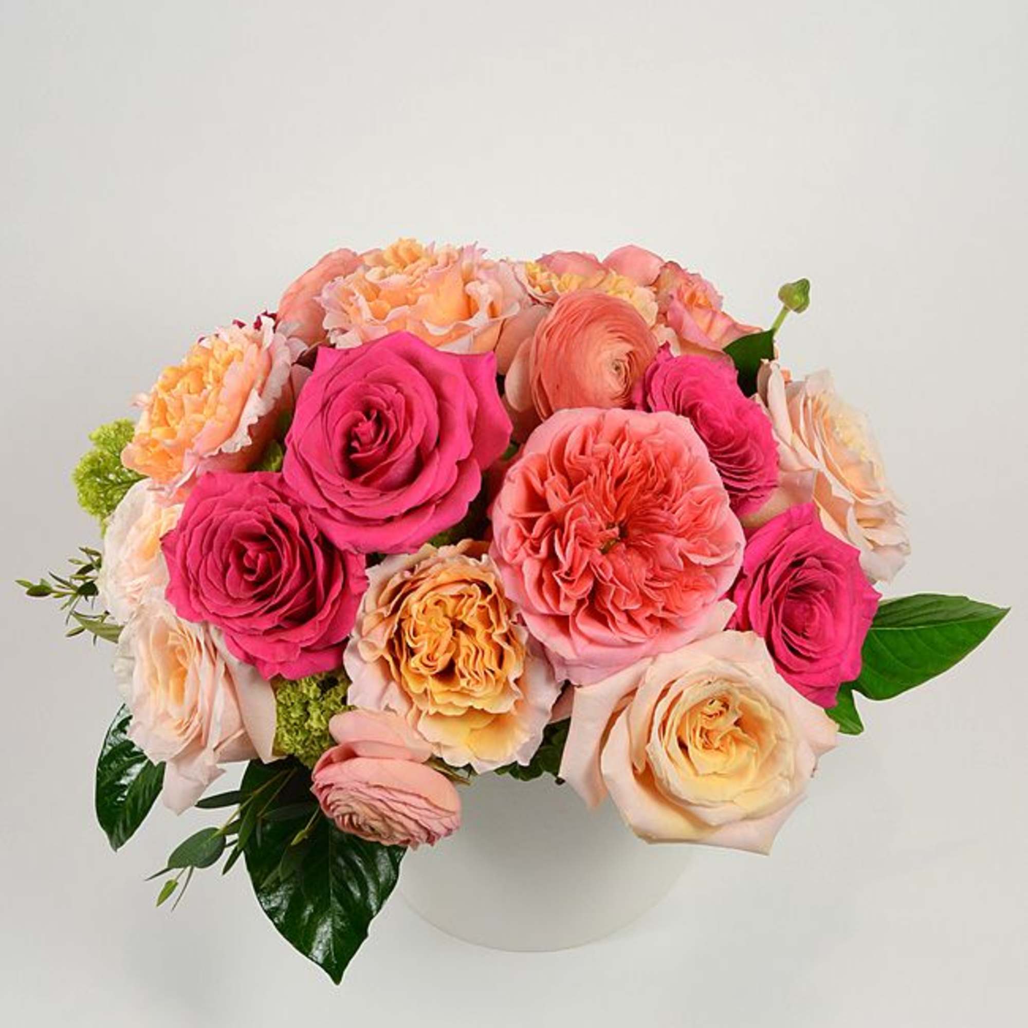 A lush cluster of garden roses, ranunculus and classic roses in soft