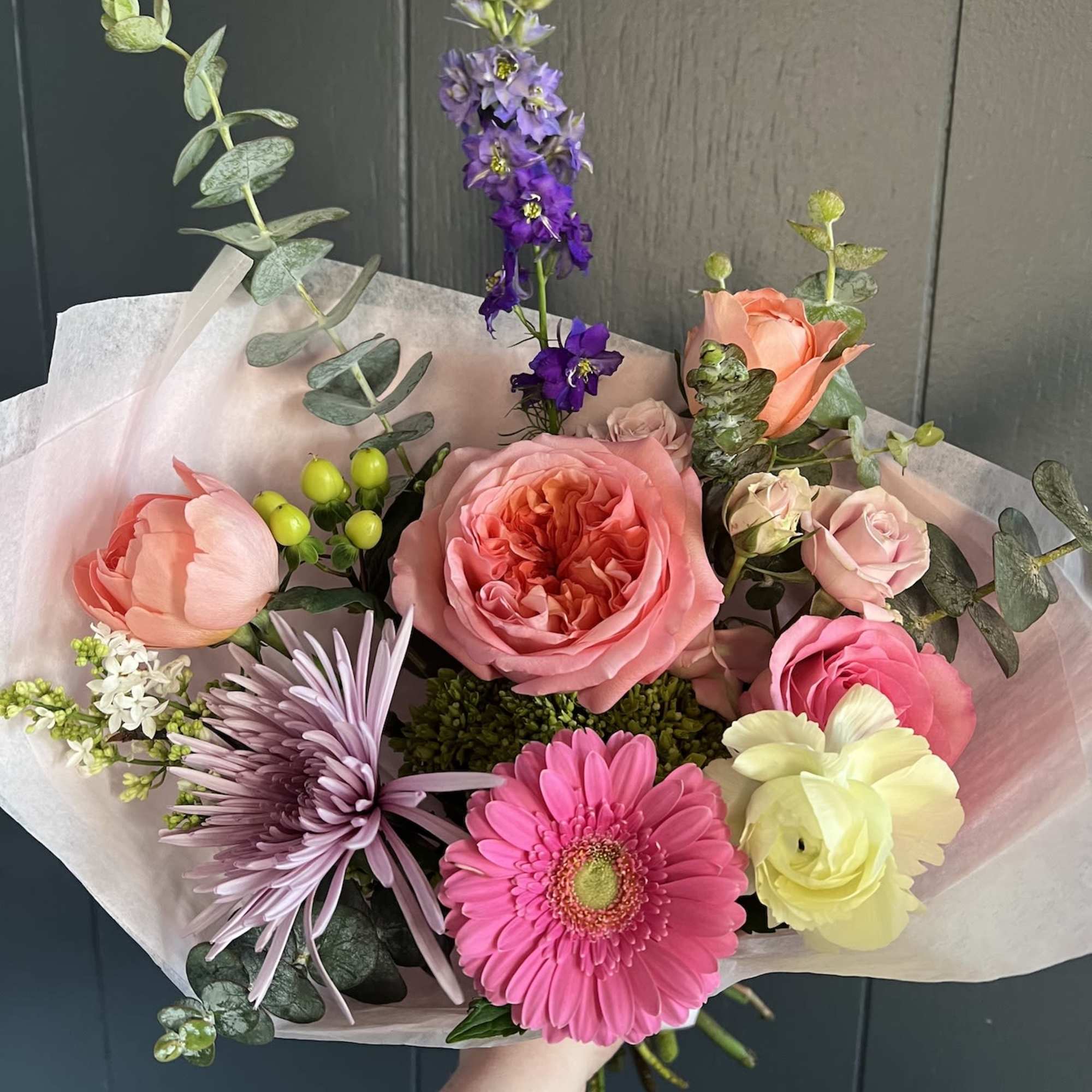 Seasonal, colorful flowers and foliage wrapped in floral paper. No vase included.

Year