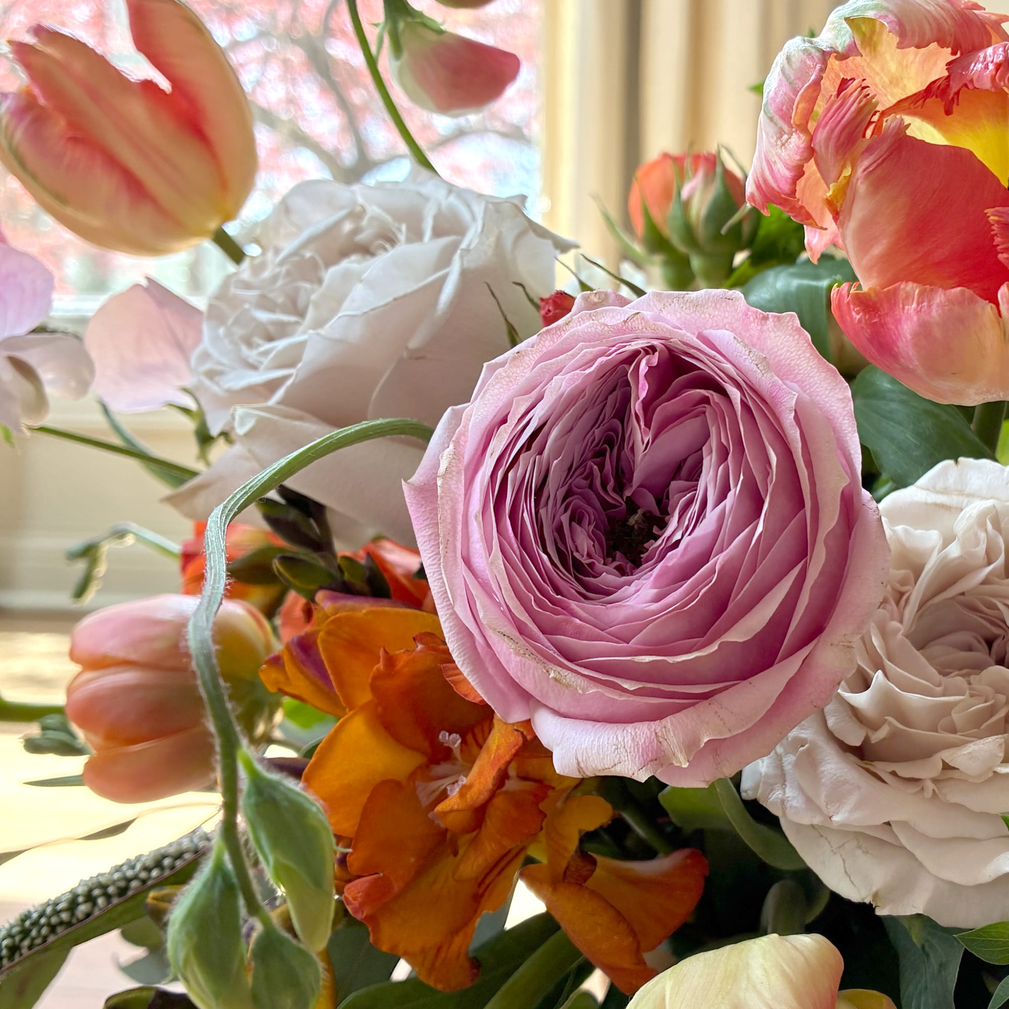 Bouquet of pink, white, and orange flowers with a large lavender bloom