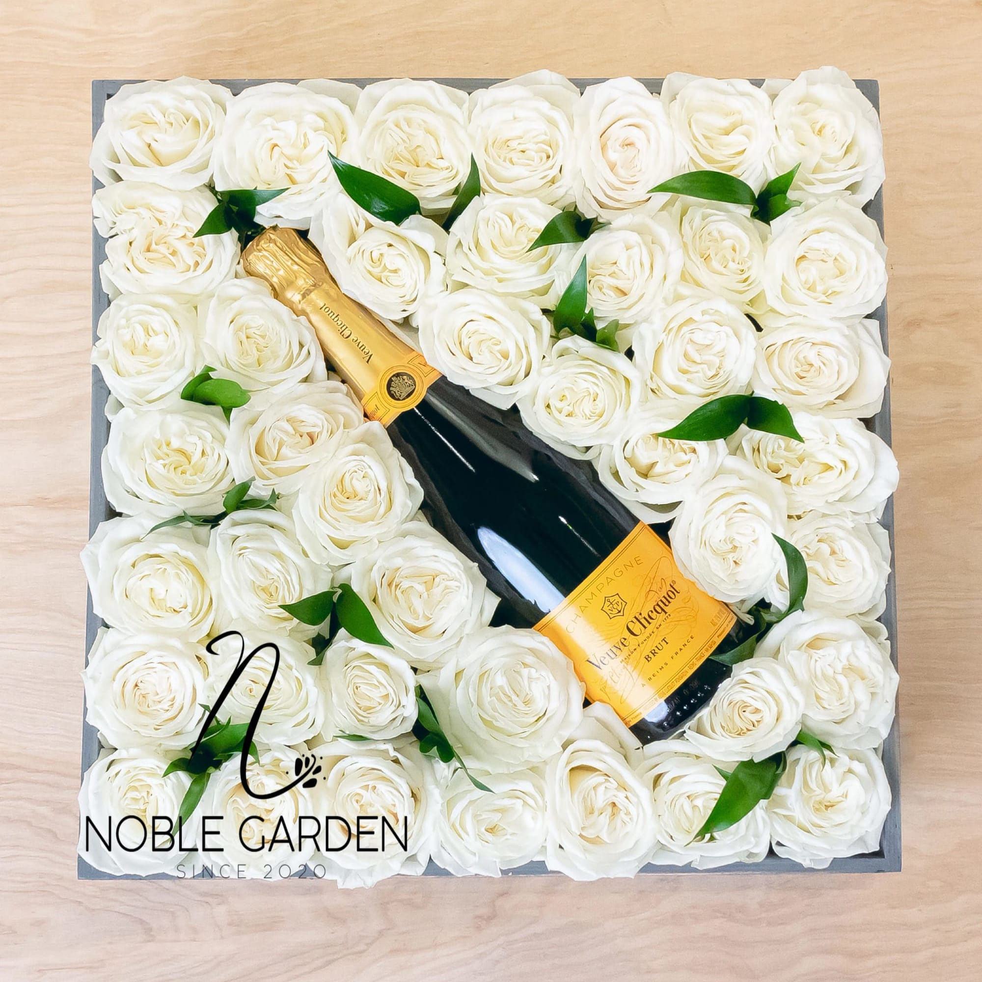 Box of white roses with a champagne bottle in the center