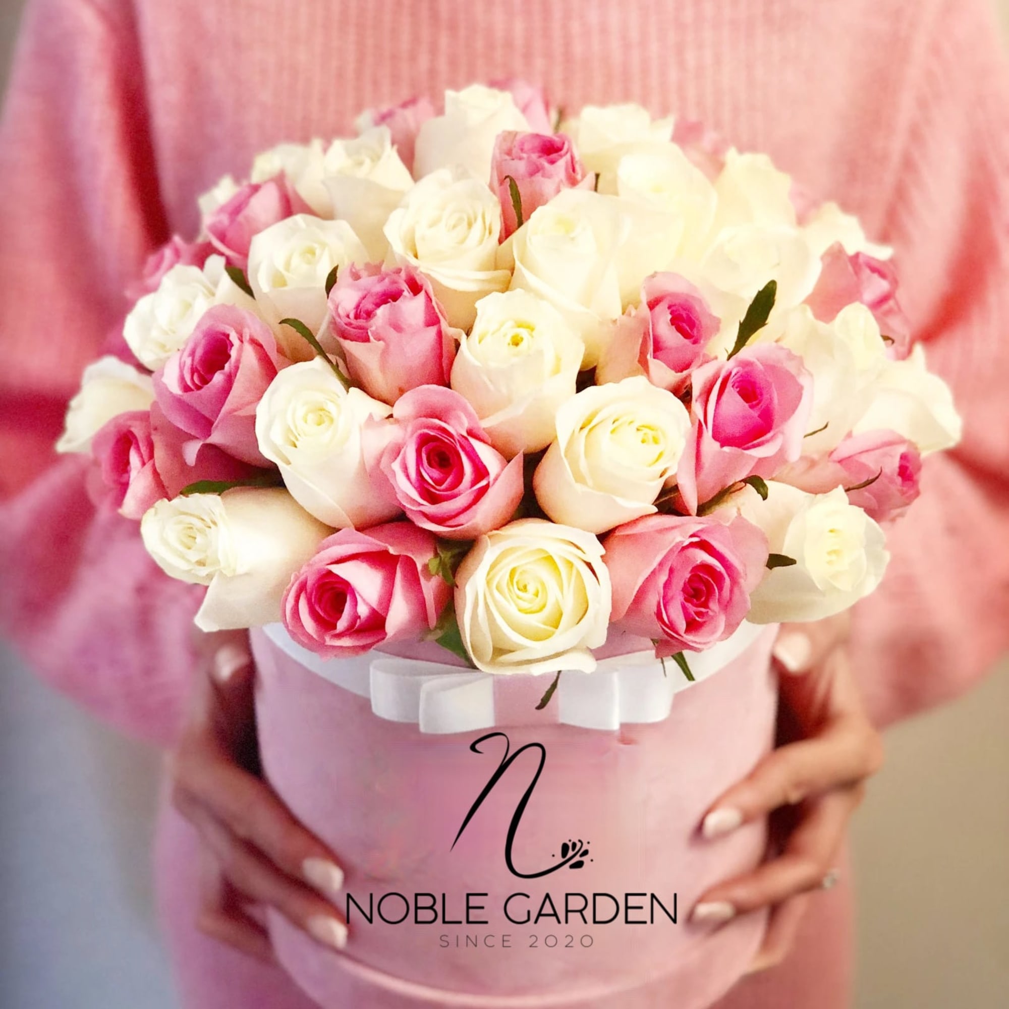 Pink and white rose bouquet in a pink hat box with a ribbon