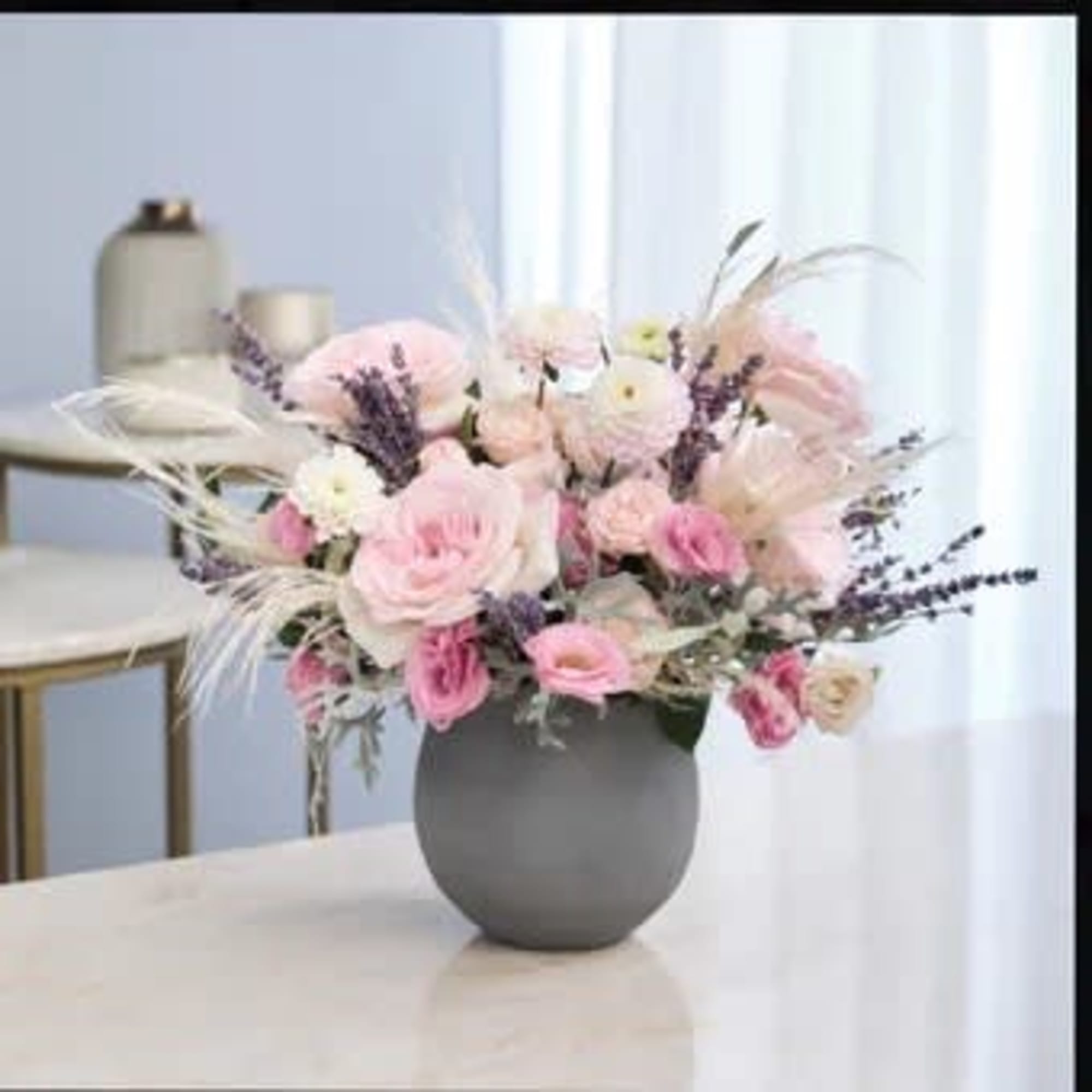 Pink and white flower arrangement in a gray vase