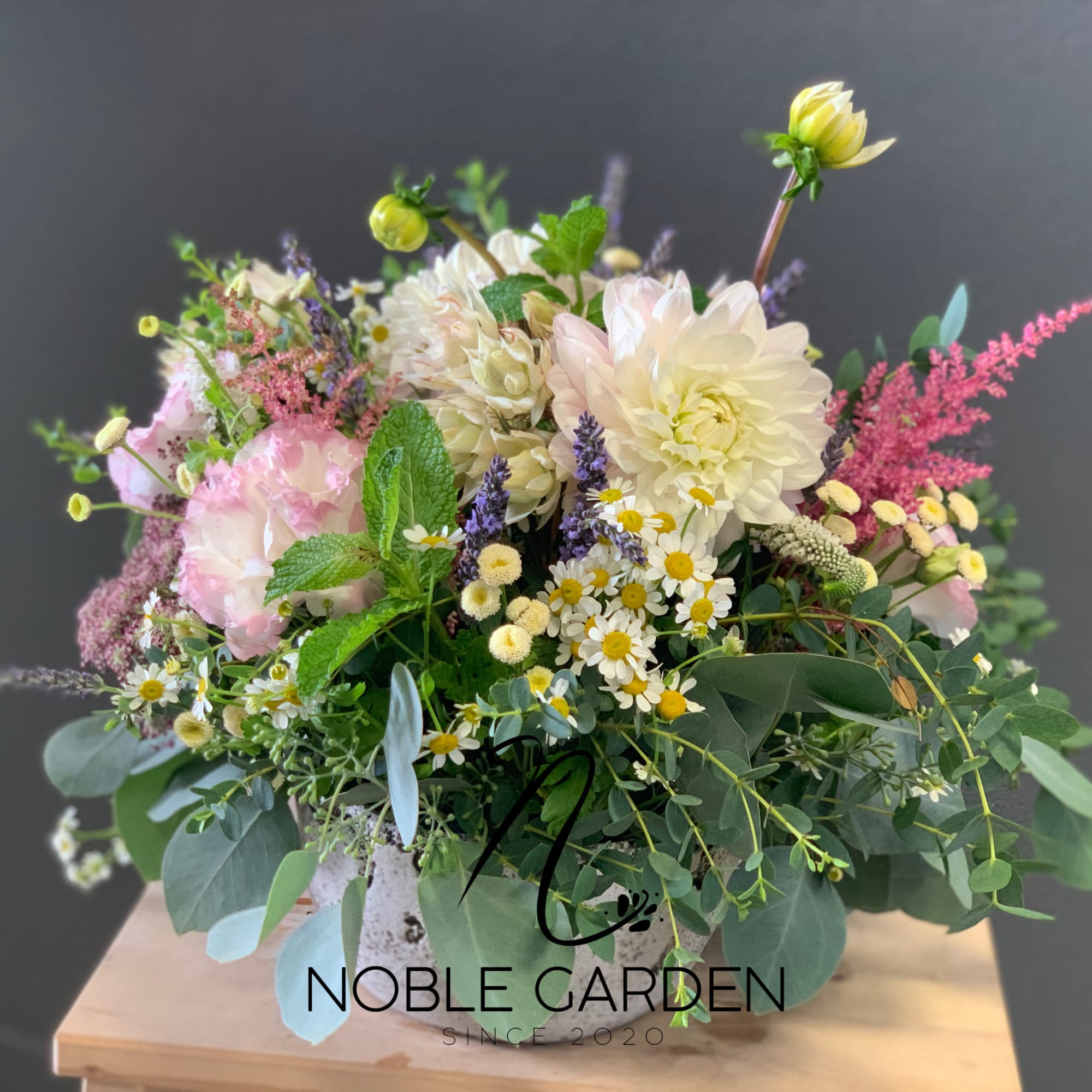 Mixed pastel flower arrangement in a white vase