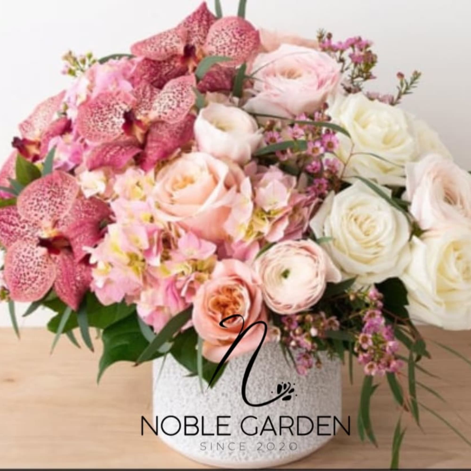 Pink and white mixed flower arrangement in a white vase