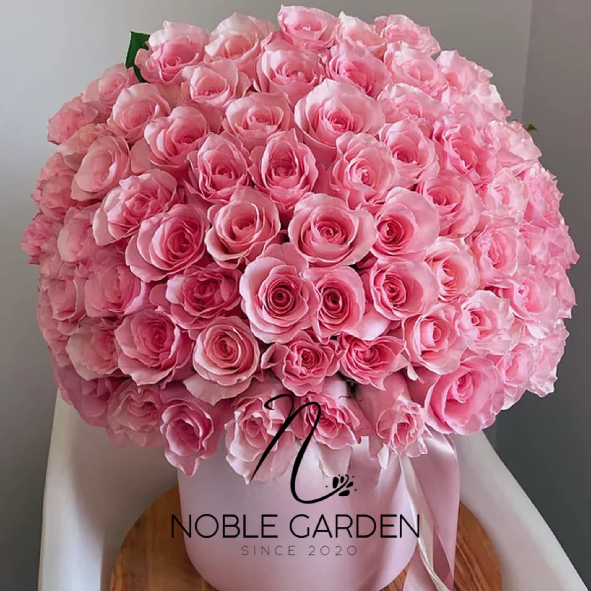 Large bouquet of pink roses in a pink hatbox with ribbon