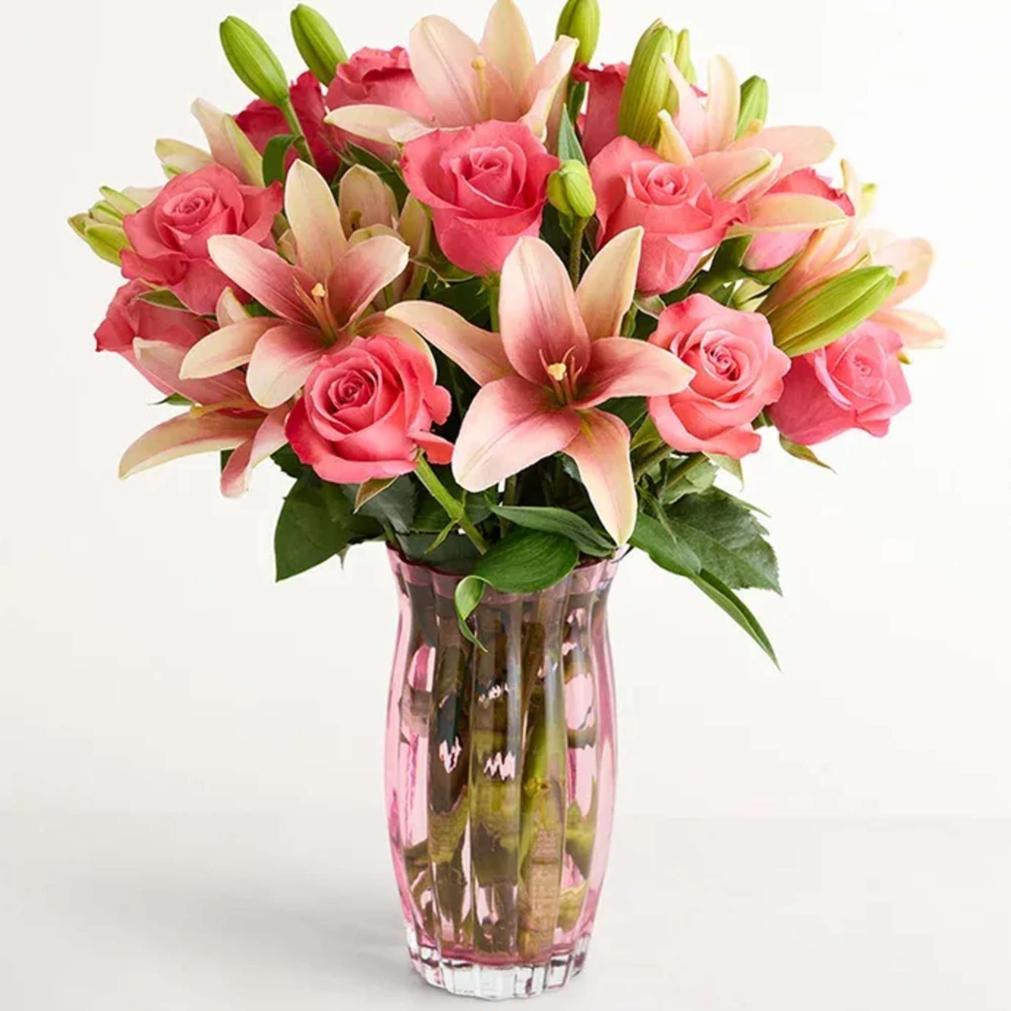 Bright pink roses mingle with pale pink-and-cream lilies in a soft, romantic