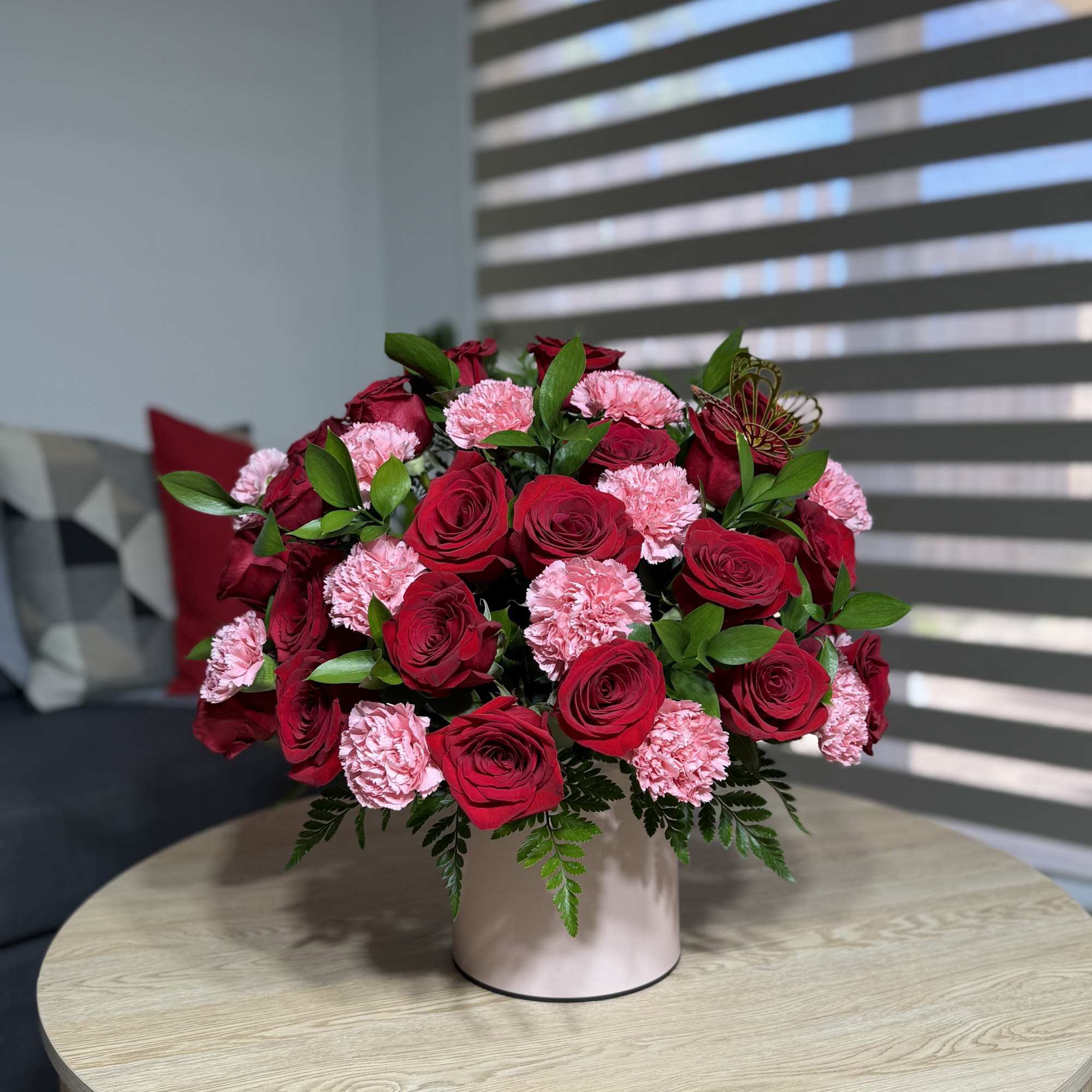 A beautiful and elegant arrangement of red roses and carnations, beautifully presented