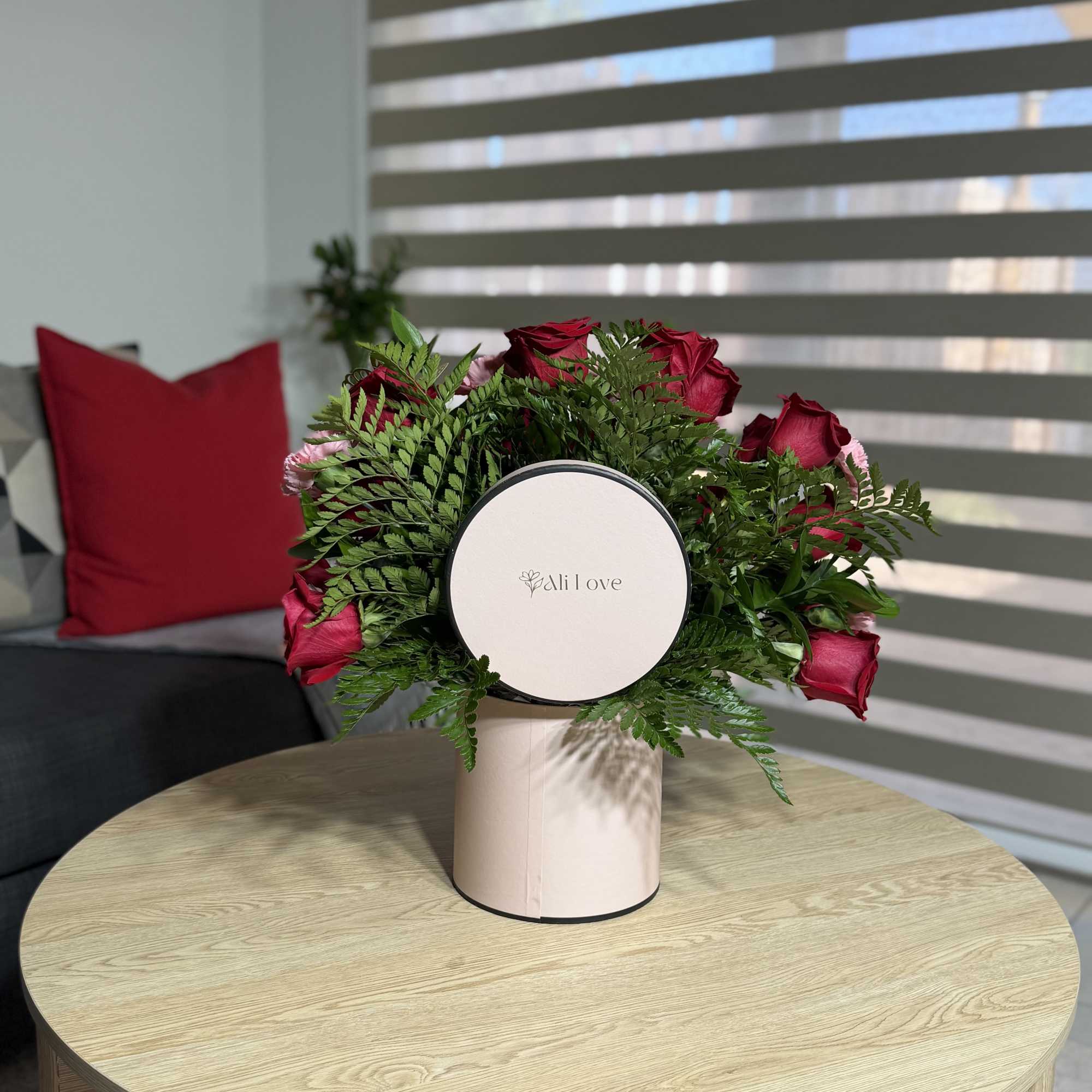 A beautiful and elegant arrangement of red roses and carnations, beautifully presented