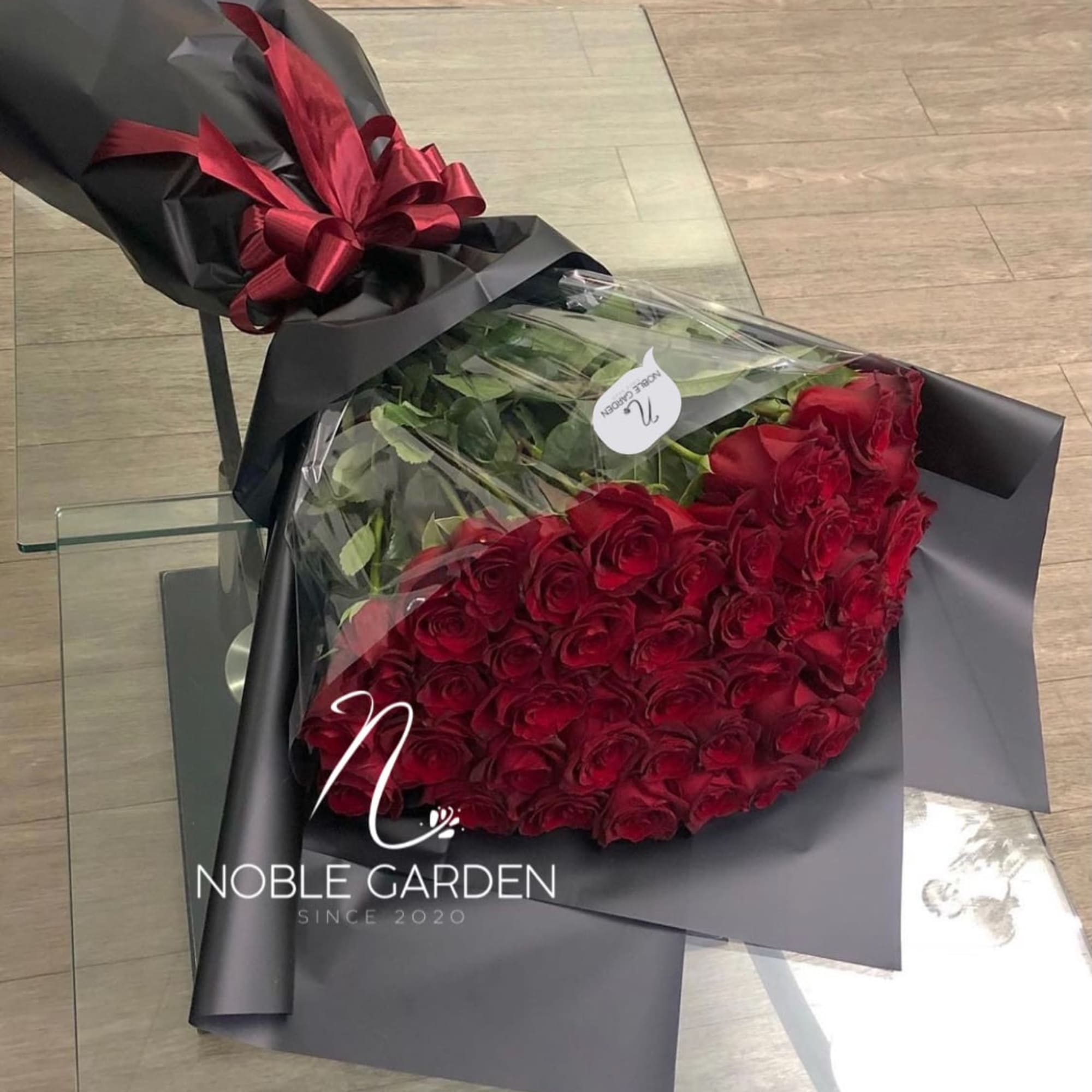 Bouquet of red roses wrapped in black paper with a red ribbon