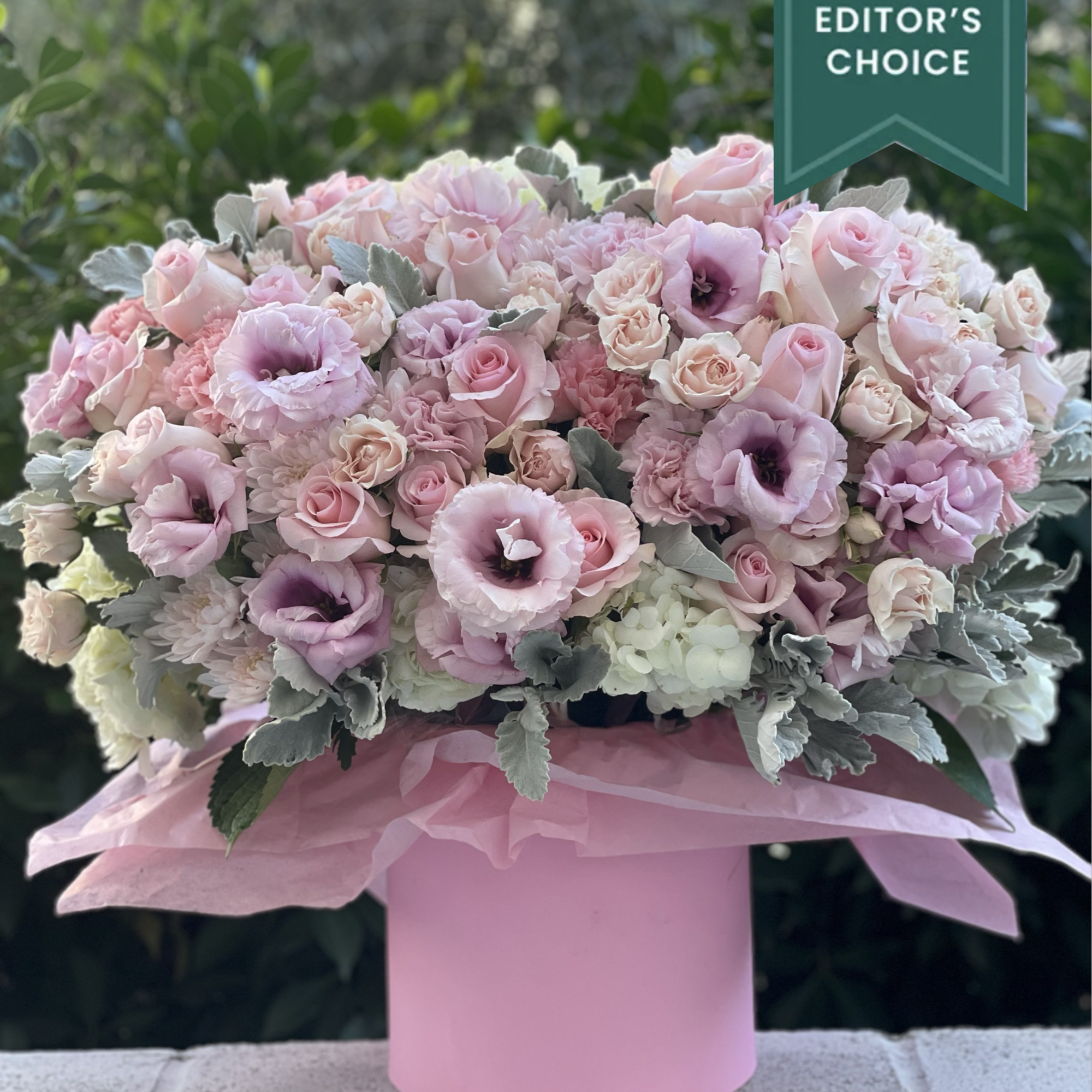 Large pastel pink and white floral arrangement in a round pink hatbox