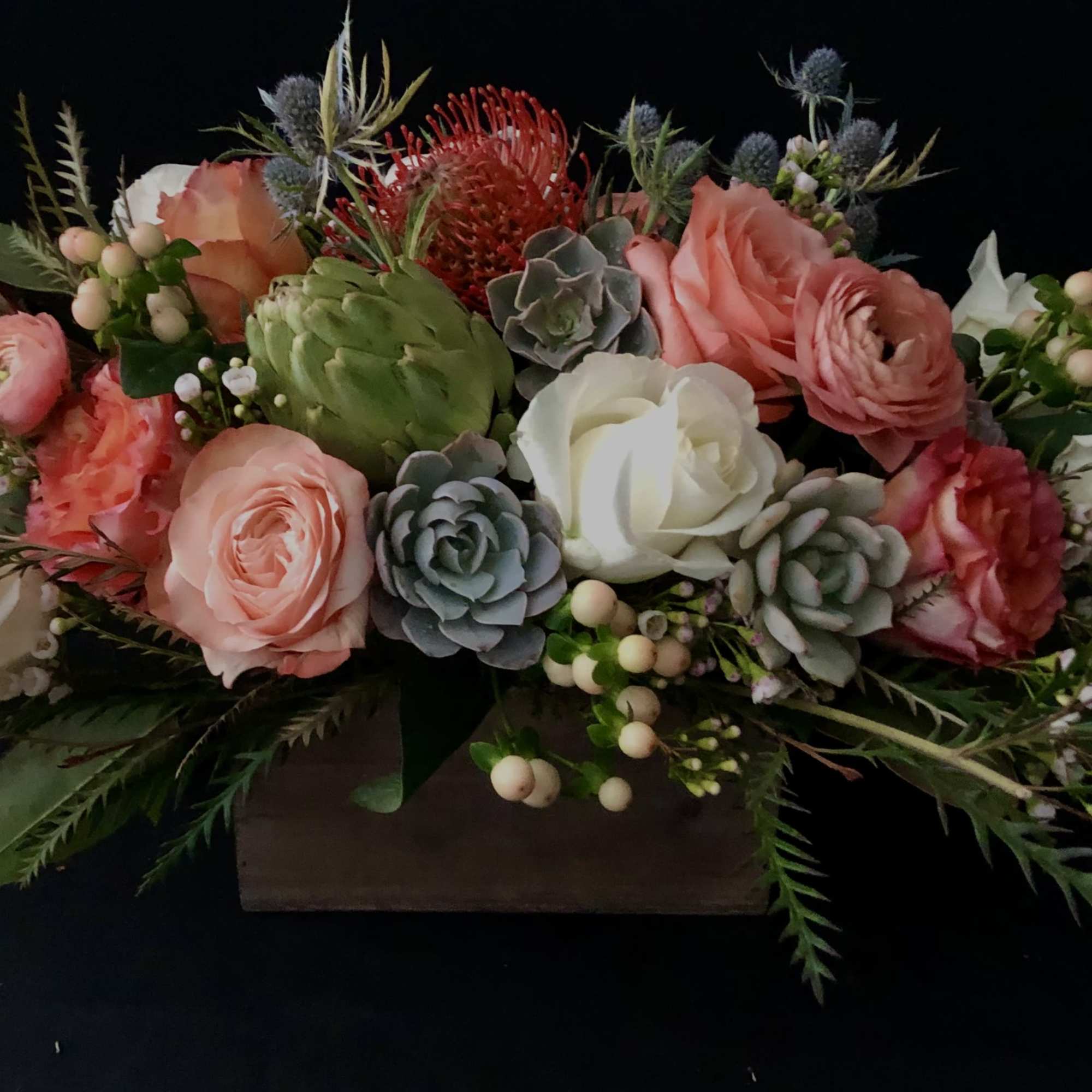Low floral arrangement with pink and white blooms in a rectangular container