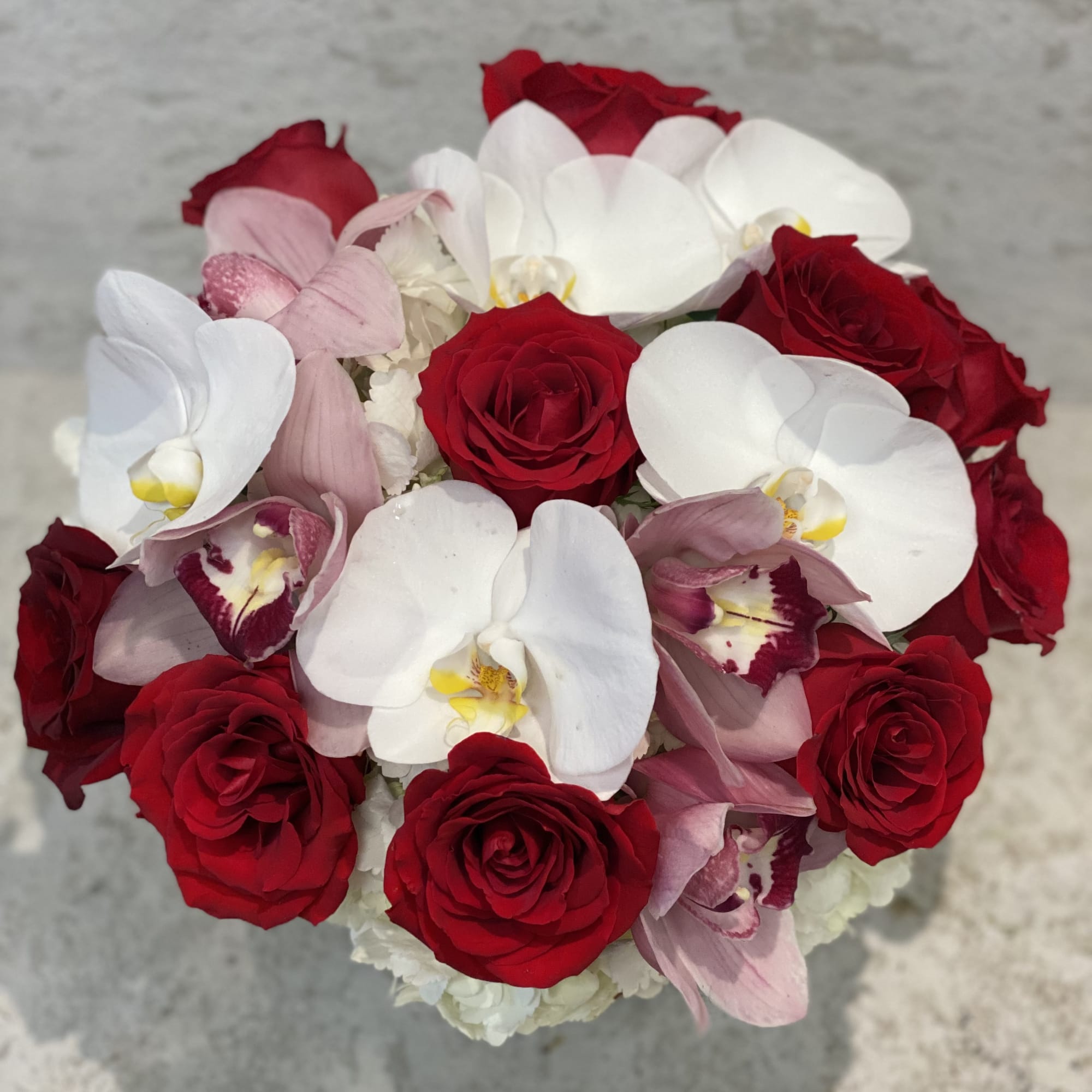 Bouquet of red roses and white orchids with pink orchids