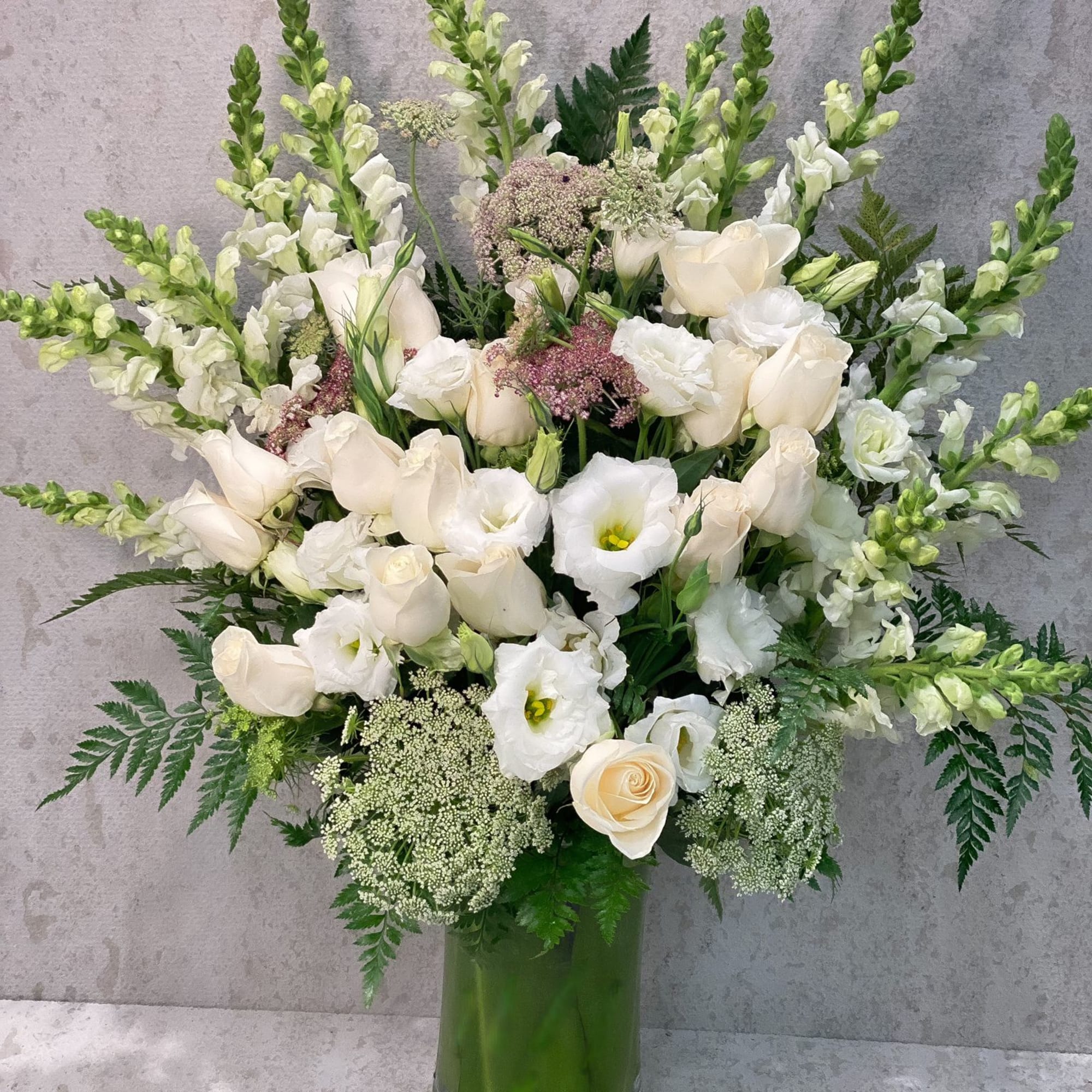 White floral arrangement in a tall glass vase