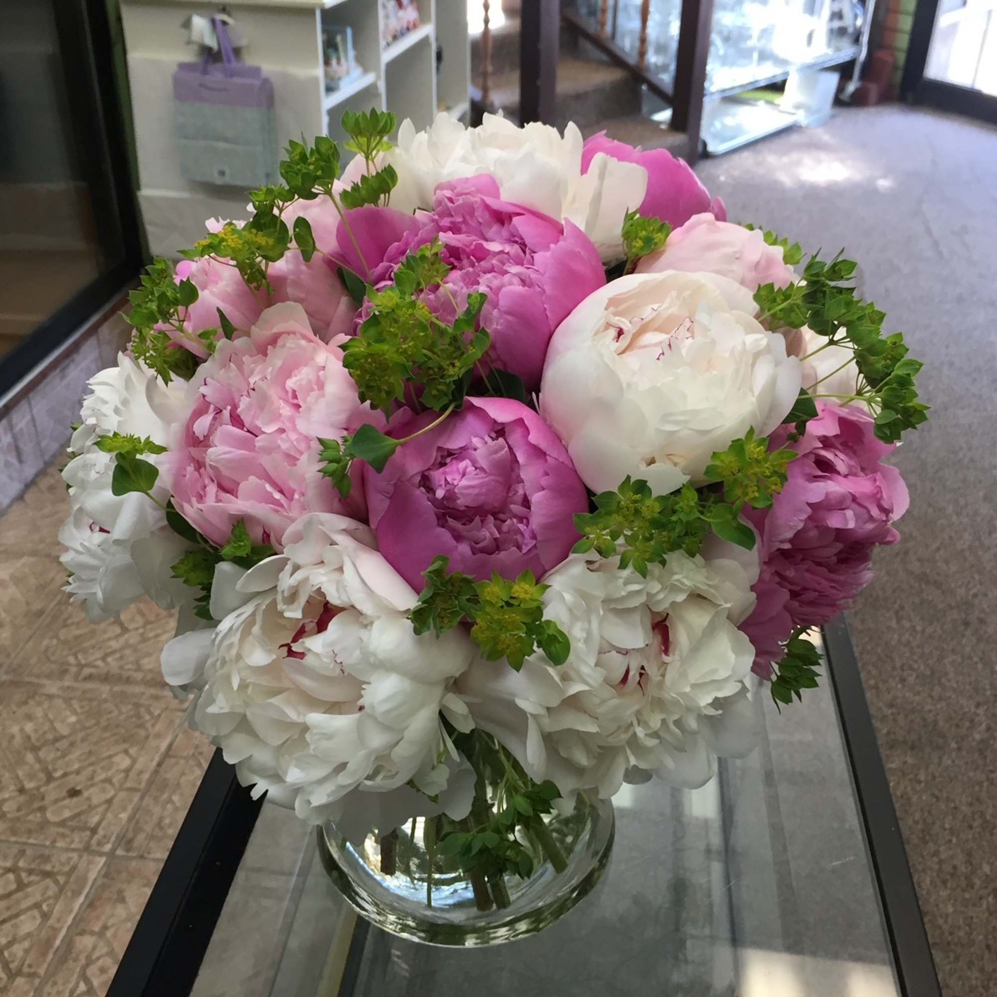 Bouquet of pink and white peonies in a clear glass vase
