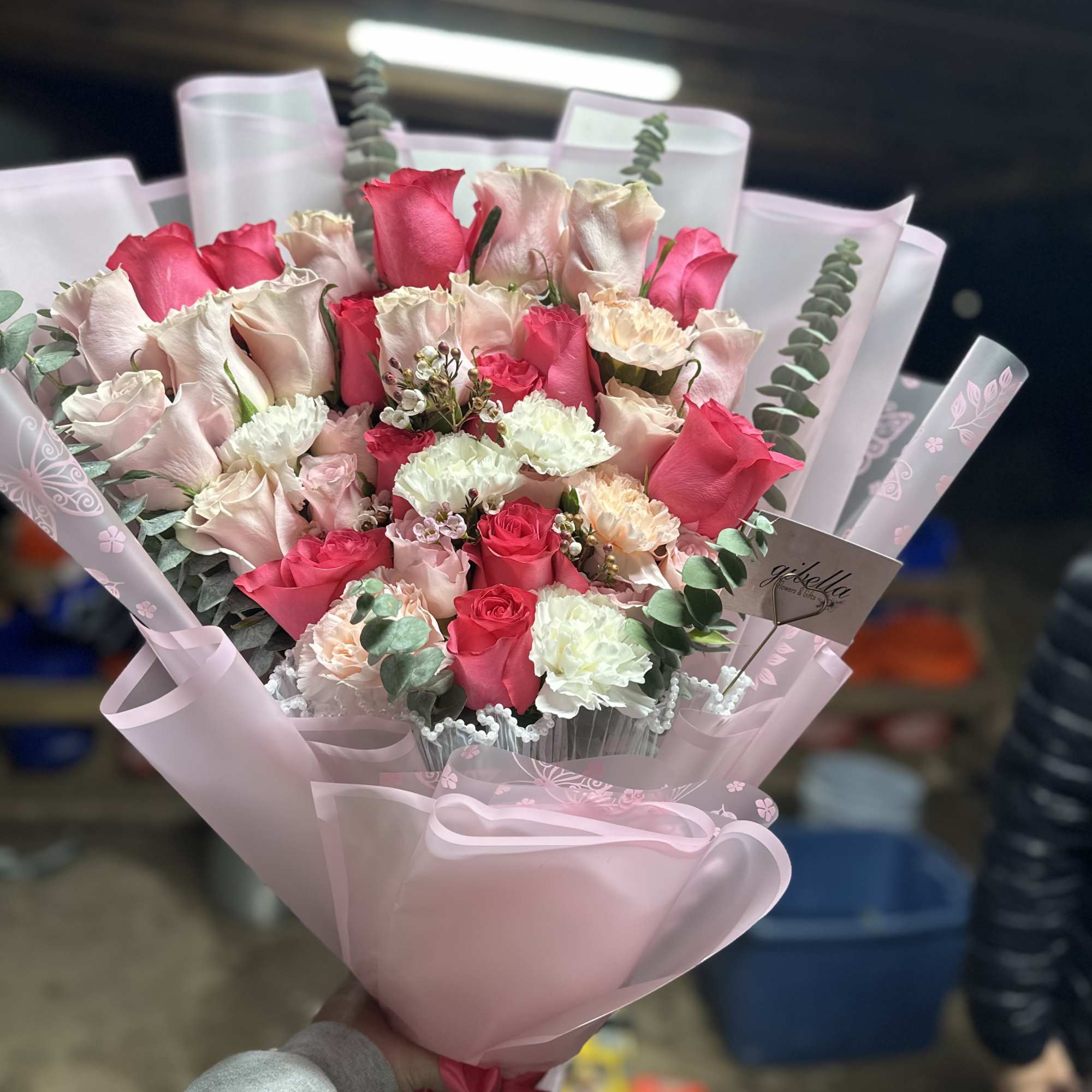 Pink and white rose bouquet wrapped in pale pink paper