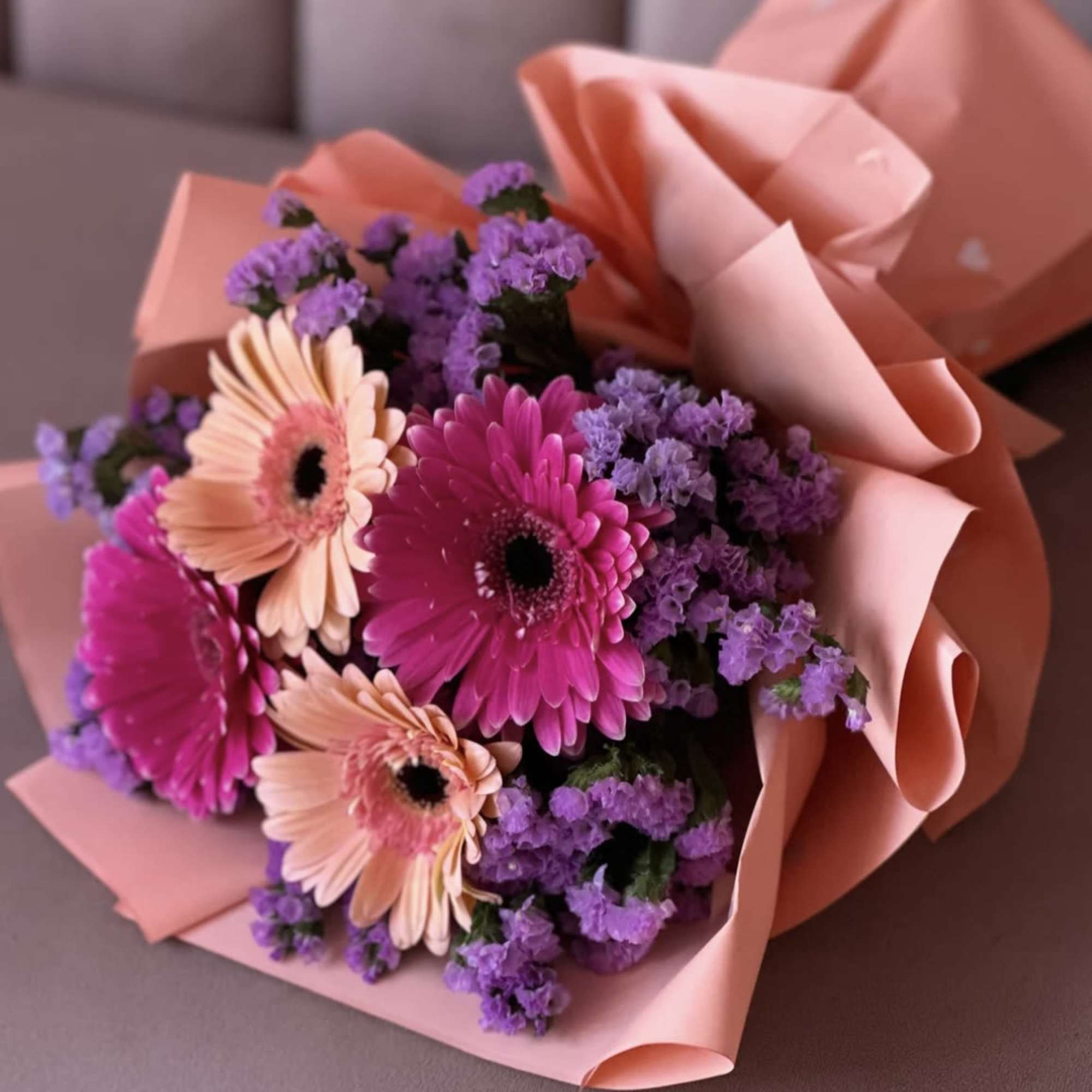 Bouquet of pink and peach gerbera daisies with purple filler flowers