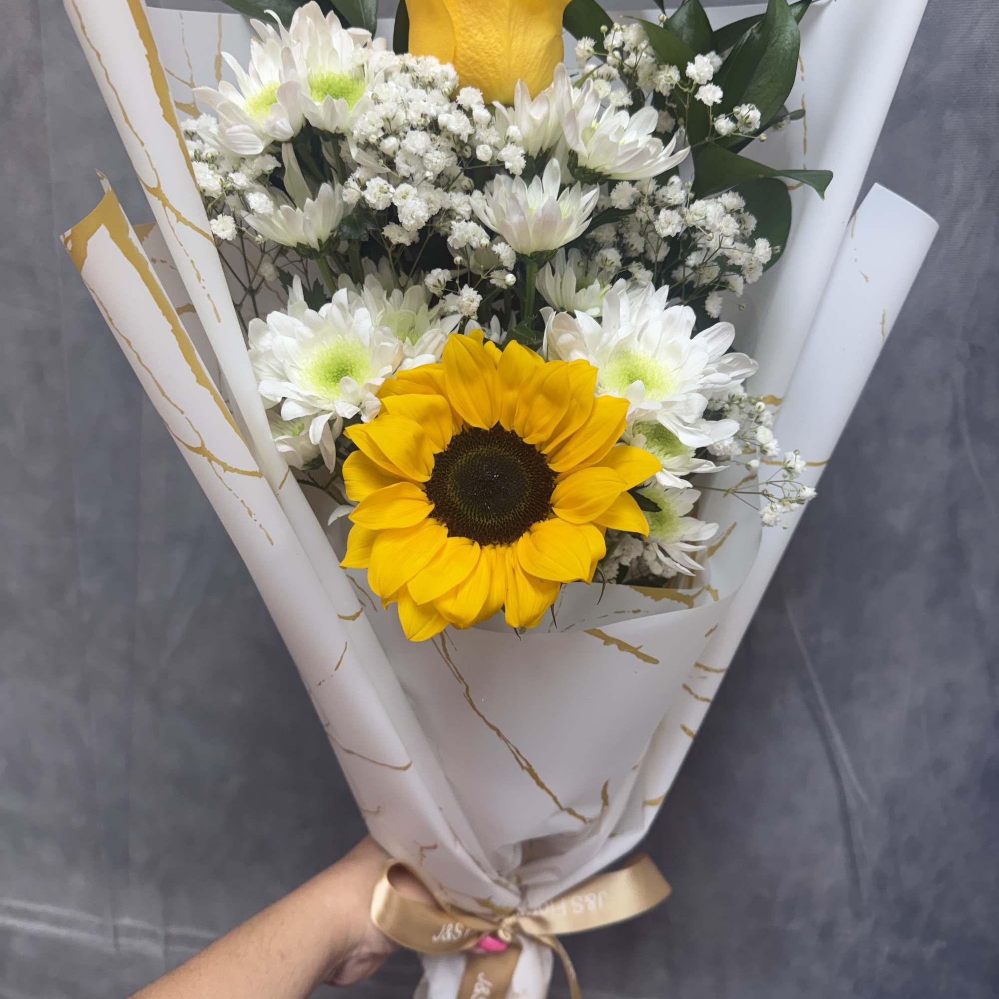 A cheerful hand-tied bouquet of bright sunflowers and sweet white daisies &mdash;