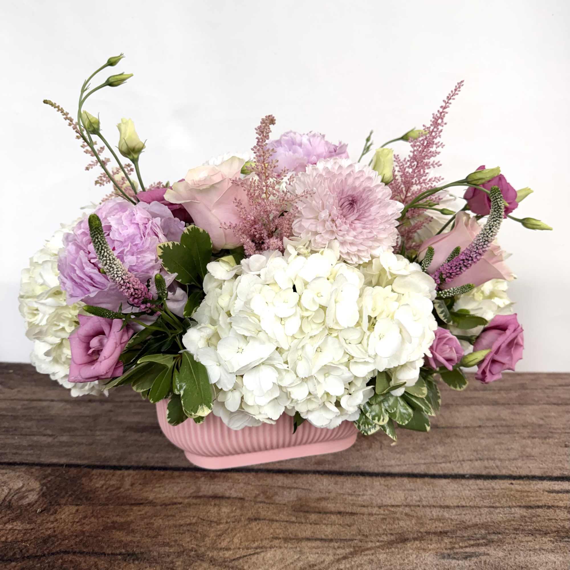 Blush pink blooms beautifully designed in a pink ceramic, textured container. Approx.