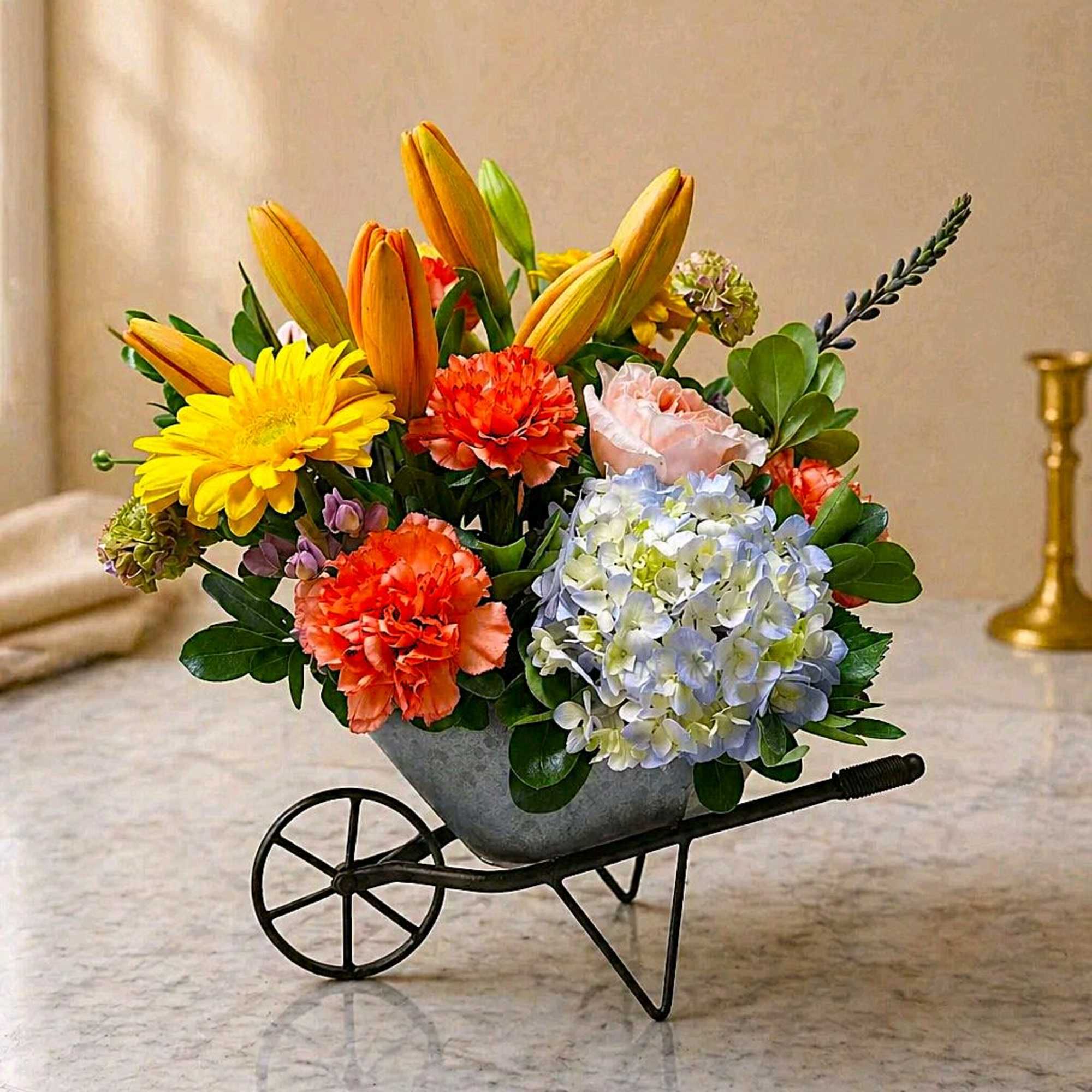 Sunlit yellow lilies and a cheerful yellow gerbera sit beside orange carnations