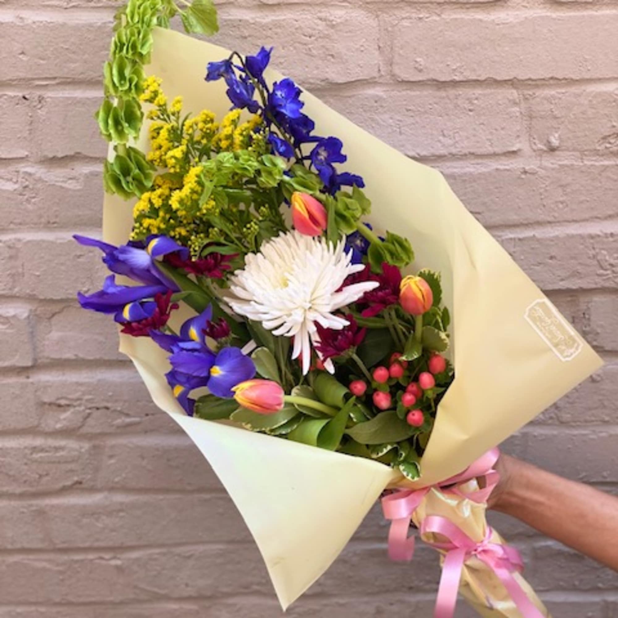 Colorful hand-tied bouquet with blue irises, white chrysanthemum, and tulips