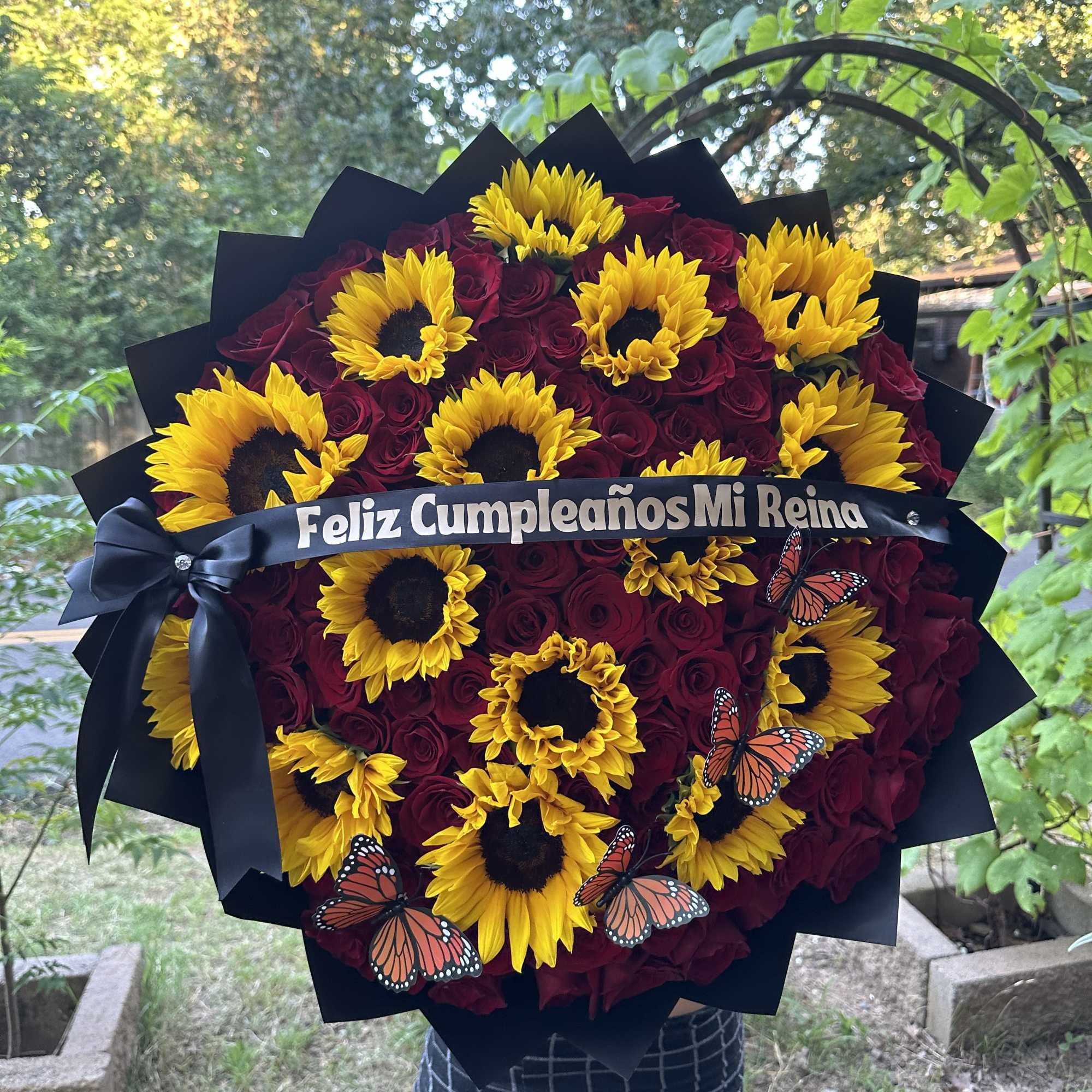 Bouquet of red roses and yellow sunflowers with a birthday ribbon