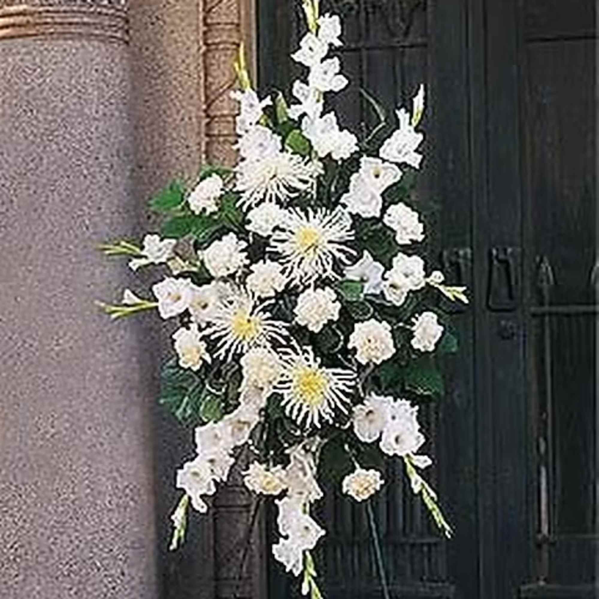 This traditional spray, filled with white carnations, chrysanthemums and gladioli, makes the